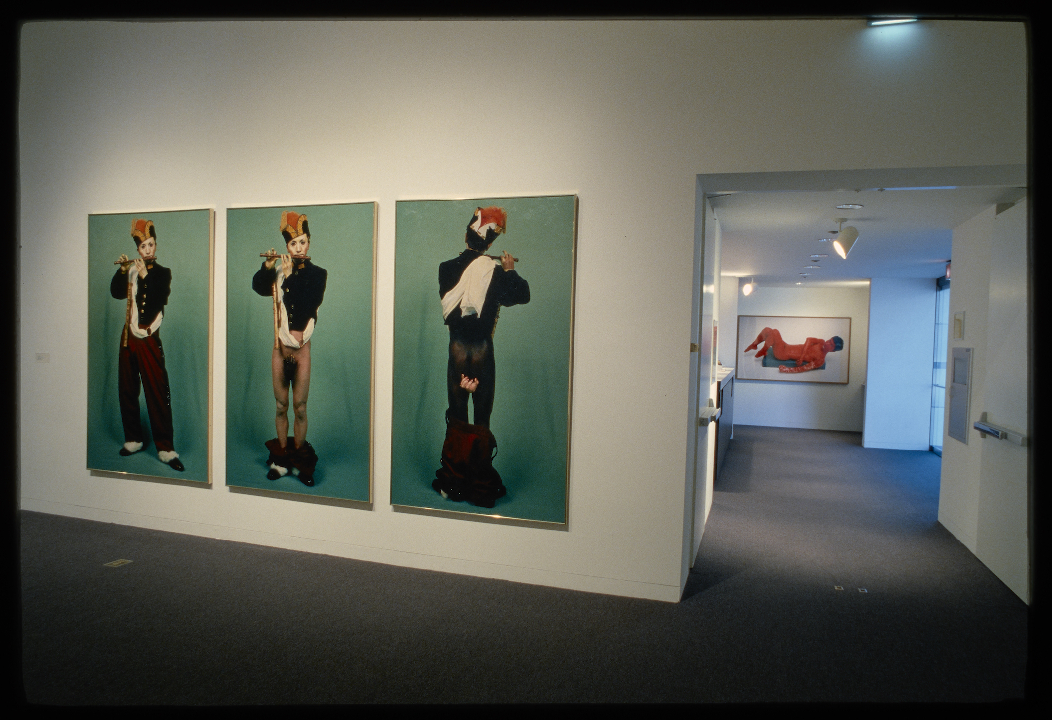 A 3 panel artwork shows a uniformed flute player with his pants lowered exposing his legs as white in one and black in another.