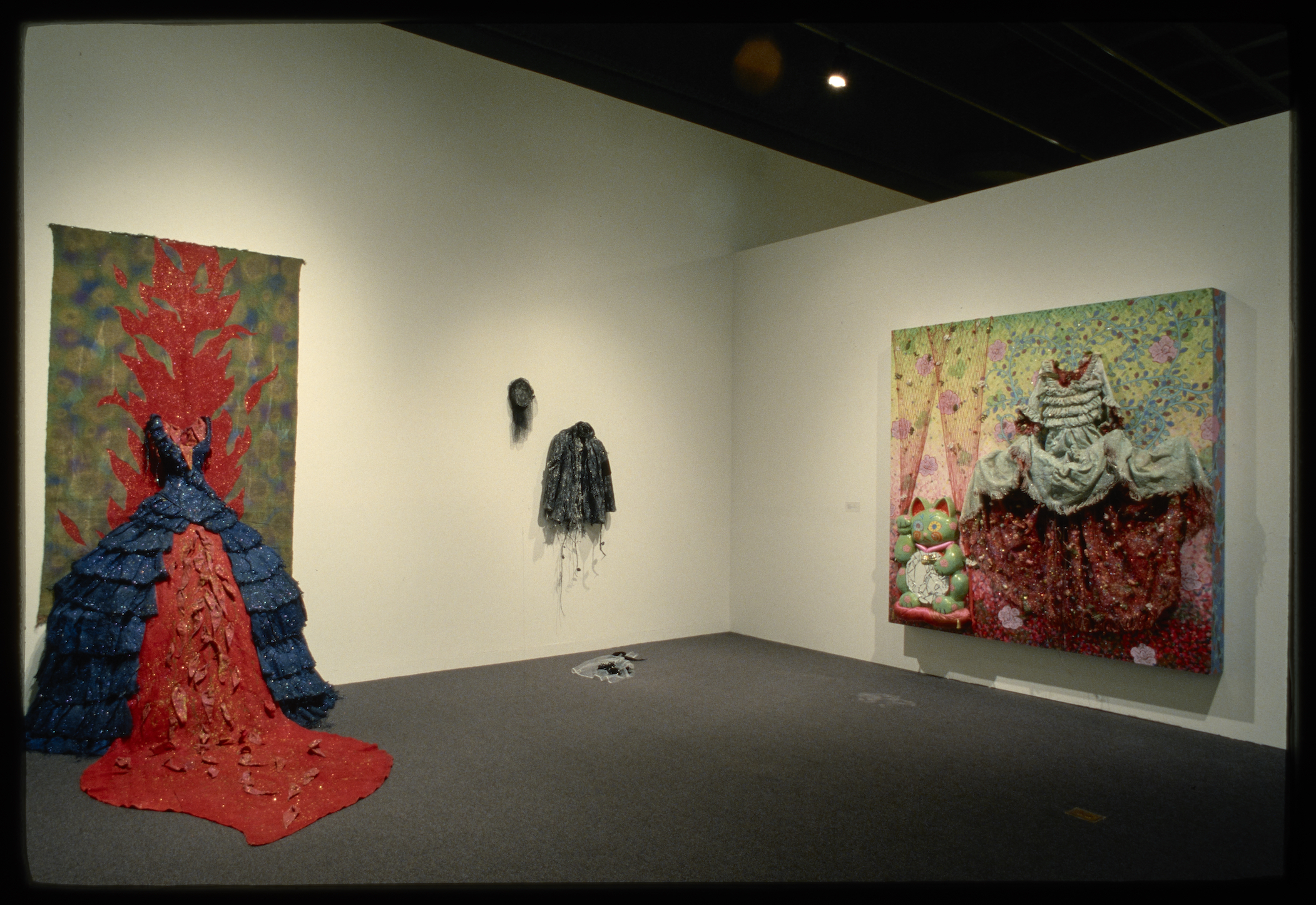 3 mixed media artworks, paintings, one looks like flames are bursting out of the top and lava is flowing out onto the floor.