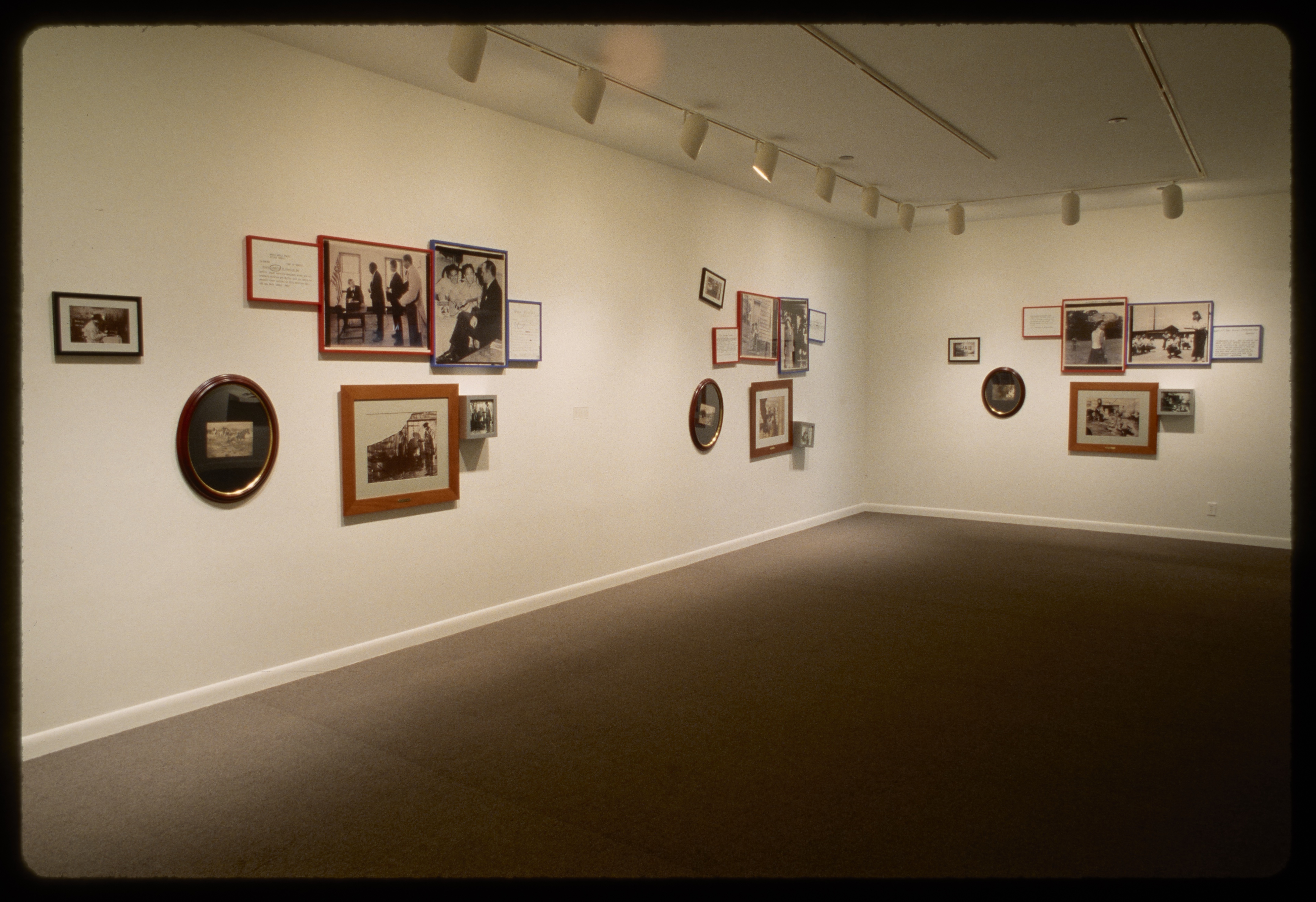 Three groups of eight framed black and white photos of different shapes and sizes hang on adjacent gallery walls.
