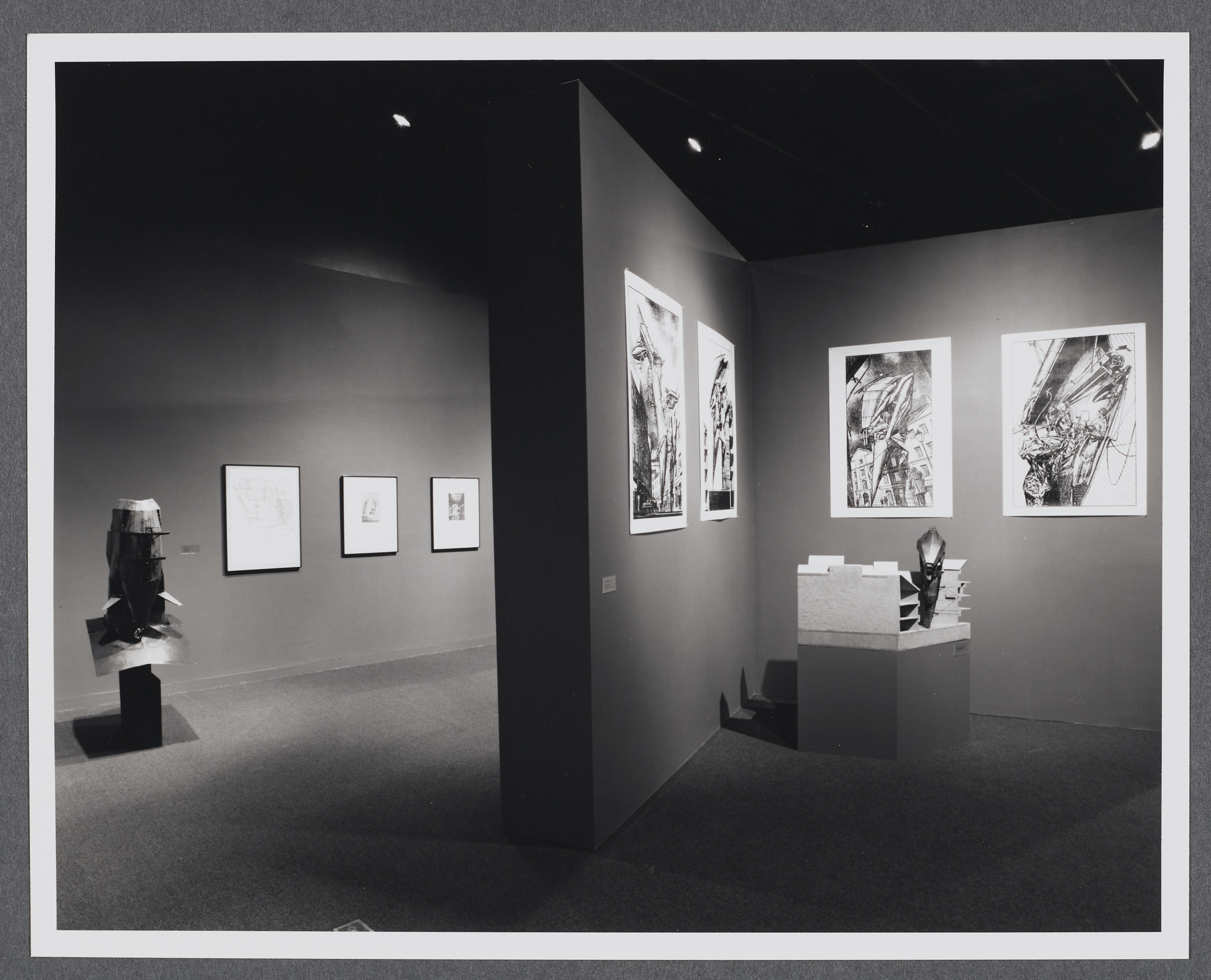 3D models sit on pedestals around the gallery. Large scale drawings hang on the gallery walls alongside the models.
