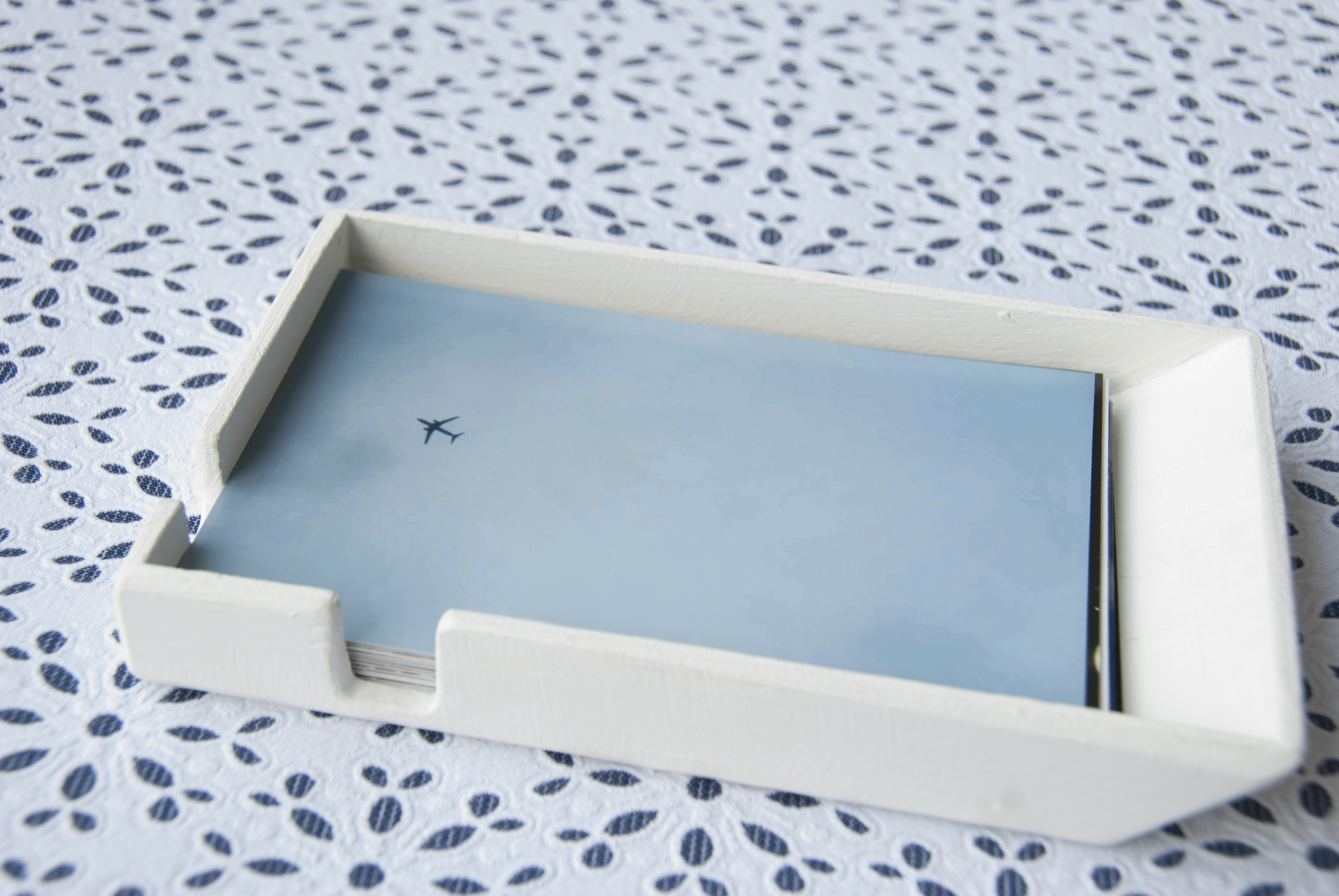 A variety of photos includes images of people and places, spread on a patterned tablecloth.