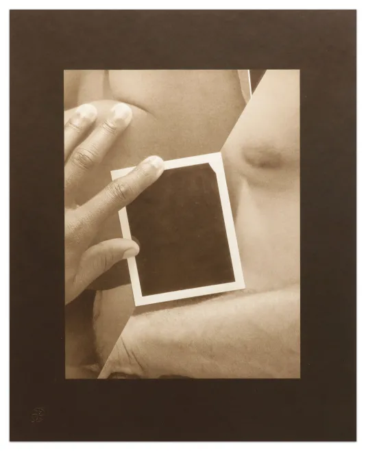 Image of a black and white photography collage with a wide black border and white frame. The central image shows a hand holding a black rectangle with a white border in front of a nude chest and arm.