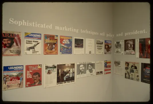 A corner of the gallery showing advertisements running in two rows around the wall with text running above them. 