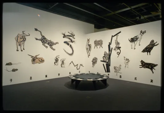 Animals of the Chinese Zodiac span across two walls with a corresponding symbol underneath and a 12 sided table in front.