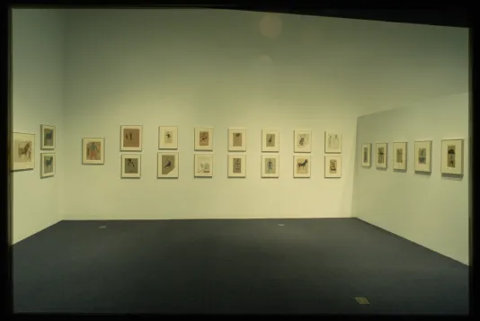 Framed drawings of figures and animals are hung on the gallery walls. 