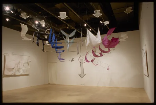Large flying kite installed in a gallery made of colorful banners.