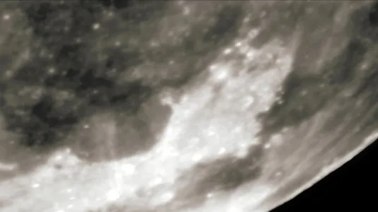 Close up of the blurred, uneven gray and white surface of a moon or planet