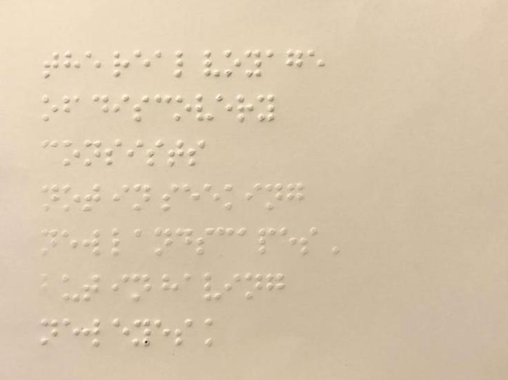 Cream colored postcard with Braille writing on it.