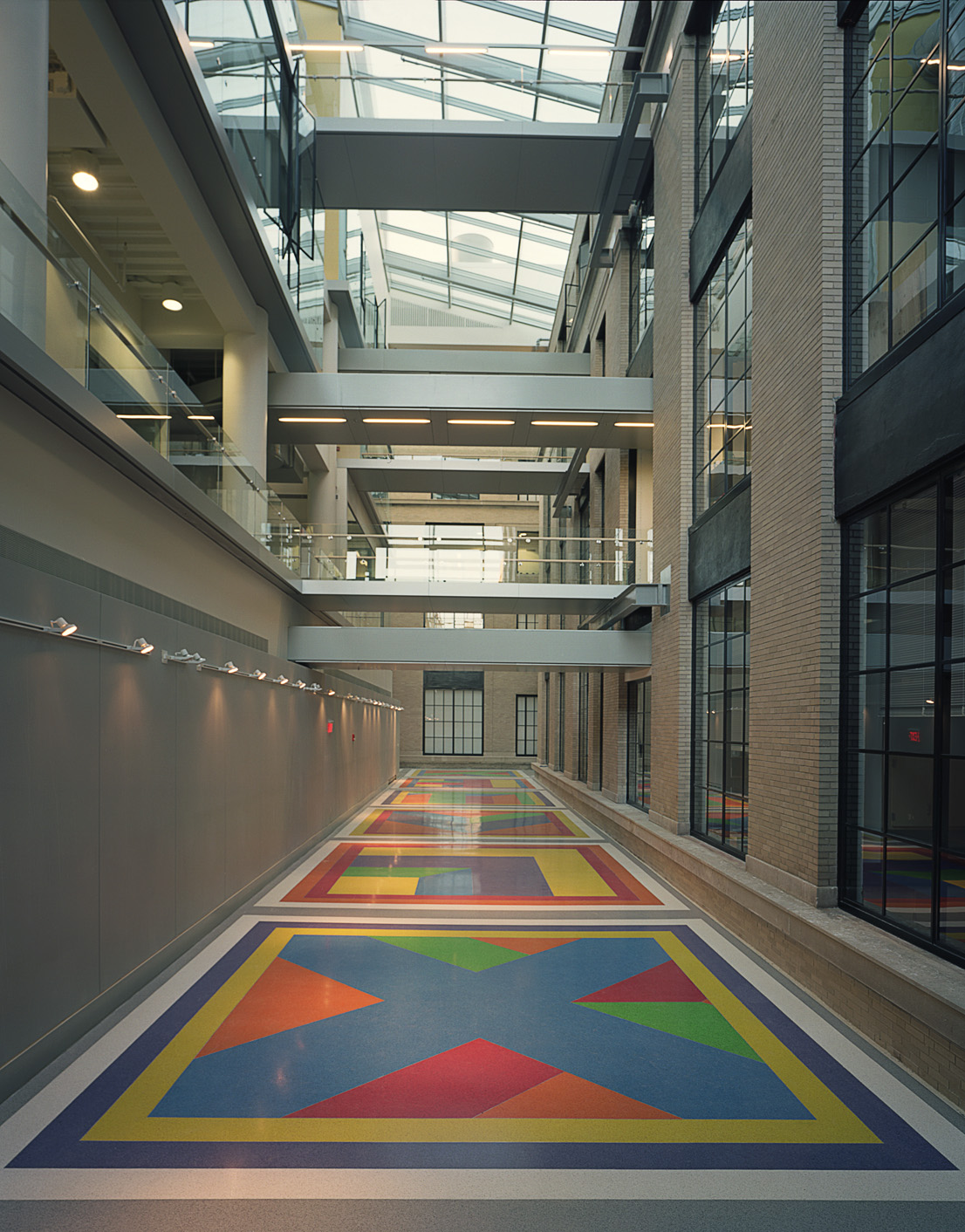 Sol Lewitt's colorful Terrazzo floor including red, green, orange, purple, and yellow tiles inside a building with high ceilings.