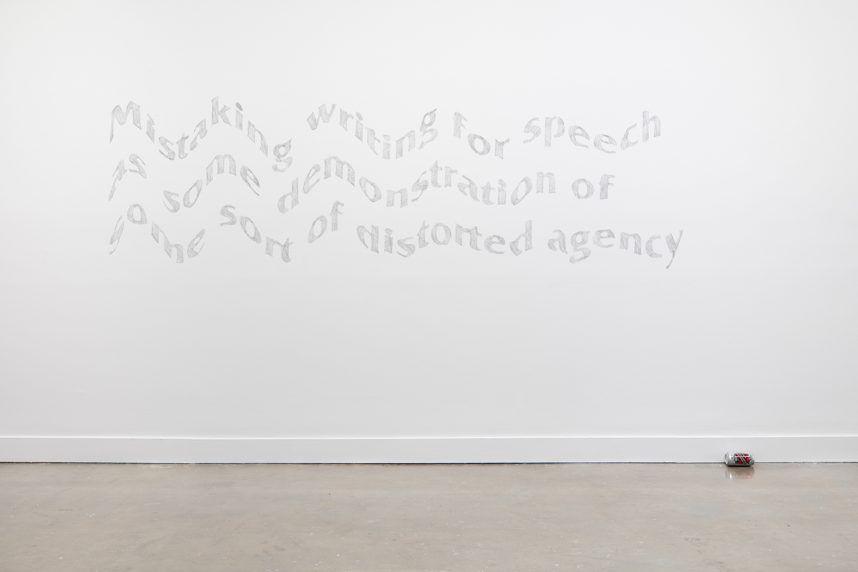 Mural featuring three lines of gray, wavy looking text on a white gallery wall with a beer can lying on its side below and slightly to the right of the mural.