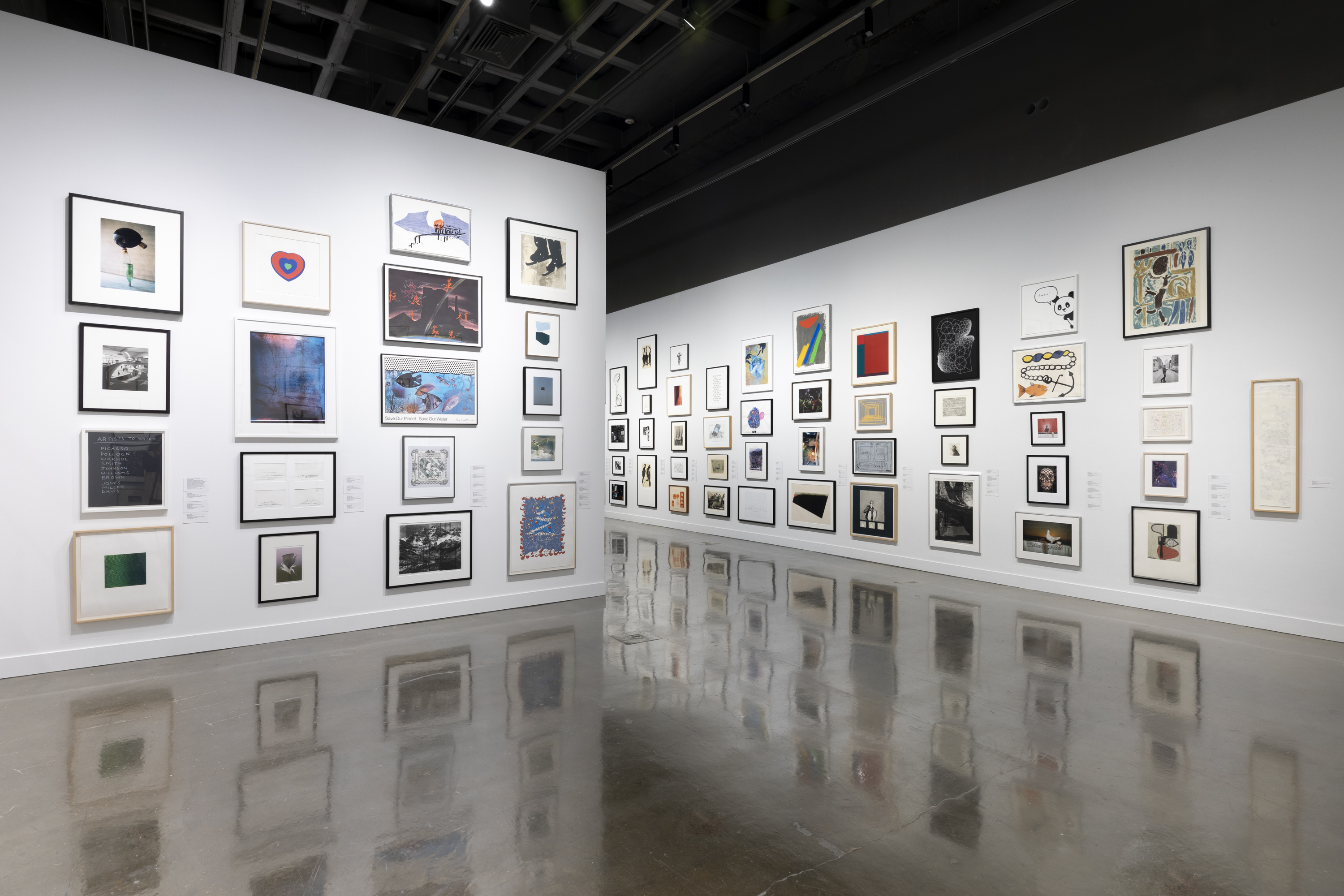 Installation view with framed artworks lining the walls floor to ceiling.