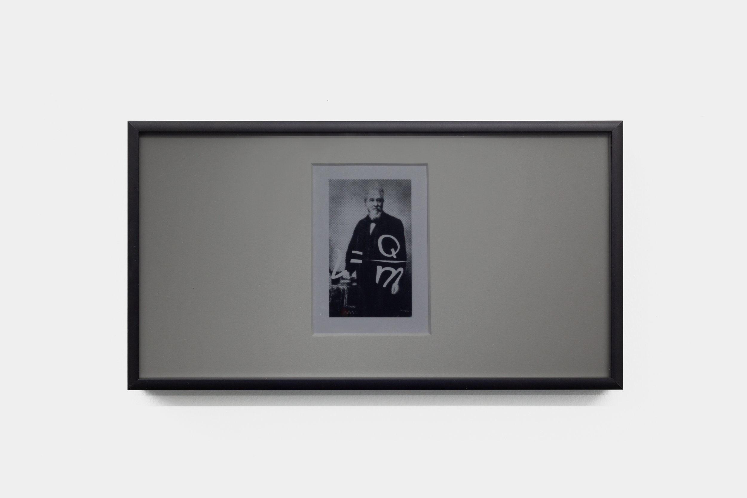 A small black-and-white portrait photograph of inventor Norbert Rillieux set in a large mat is overlaid with white text that reads: L=Qm, the equation for latent heat. The framed work has a grey tint from the privacy filter that serves as glass.