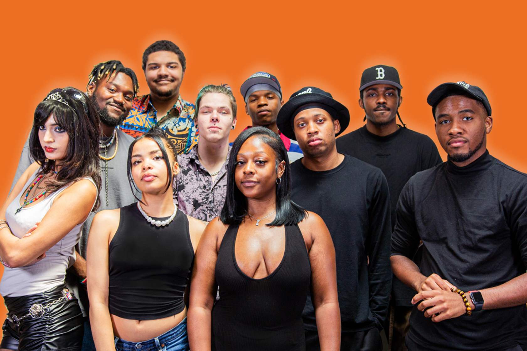 Group of people posing and looking at the camera against an orange background.