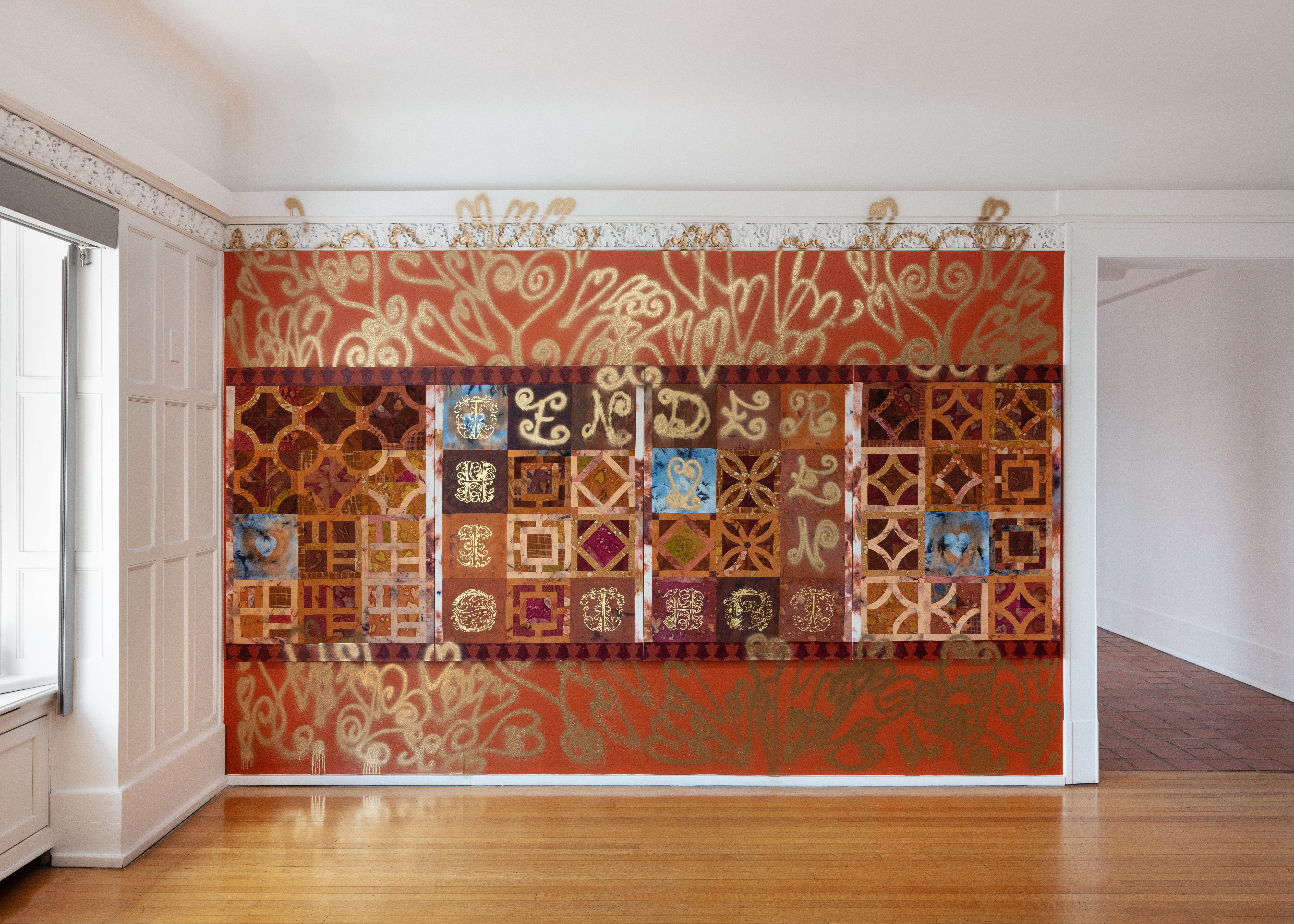 Red accent wall with geometric patterns that overflow onto the surrounding white walls and a light brown wood floor.