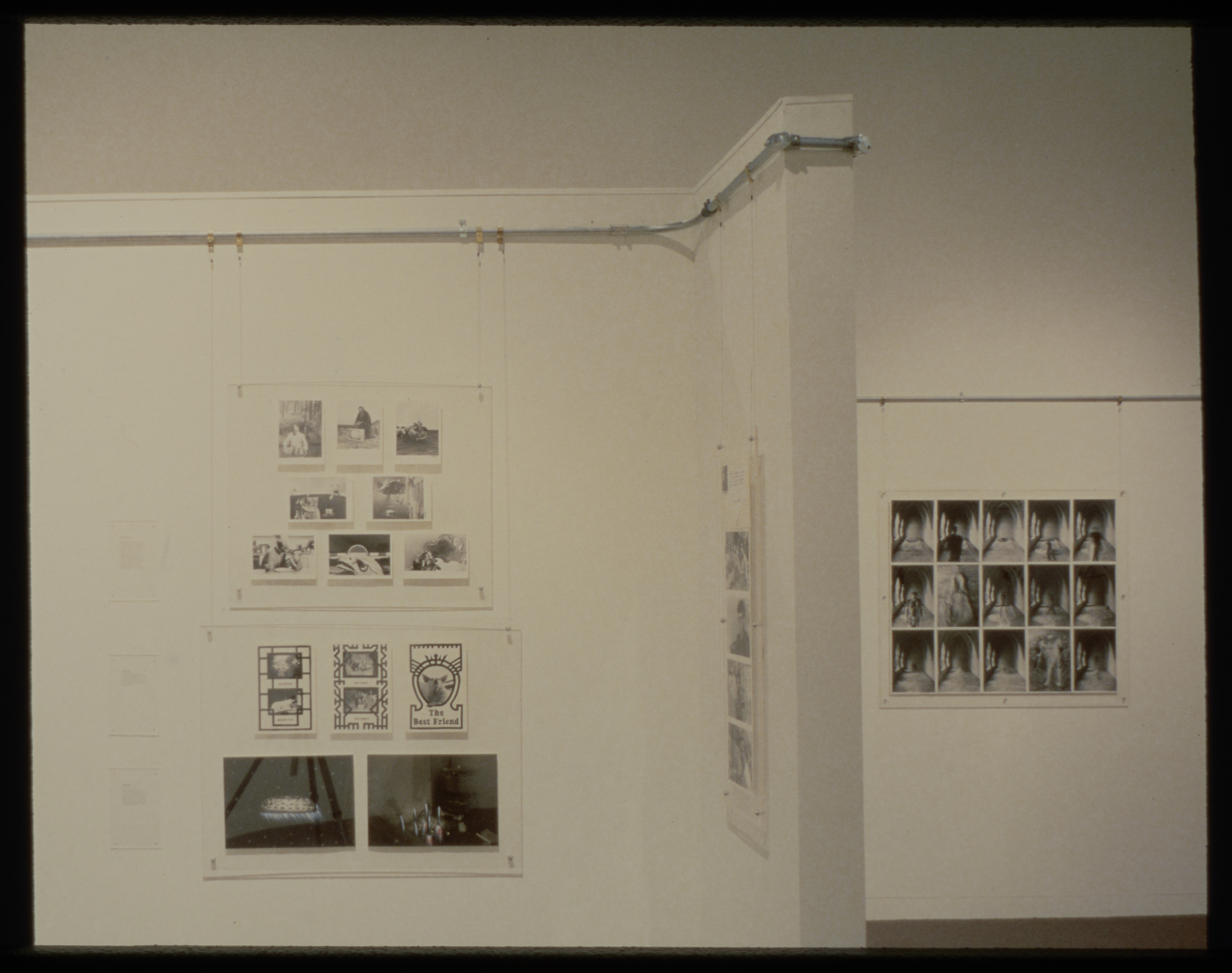 Groups of black and white photographs of varying sizes line the walls of the gallery.