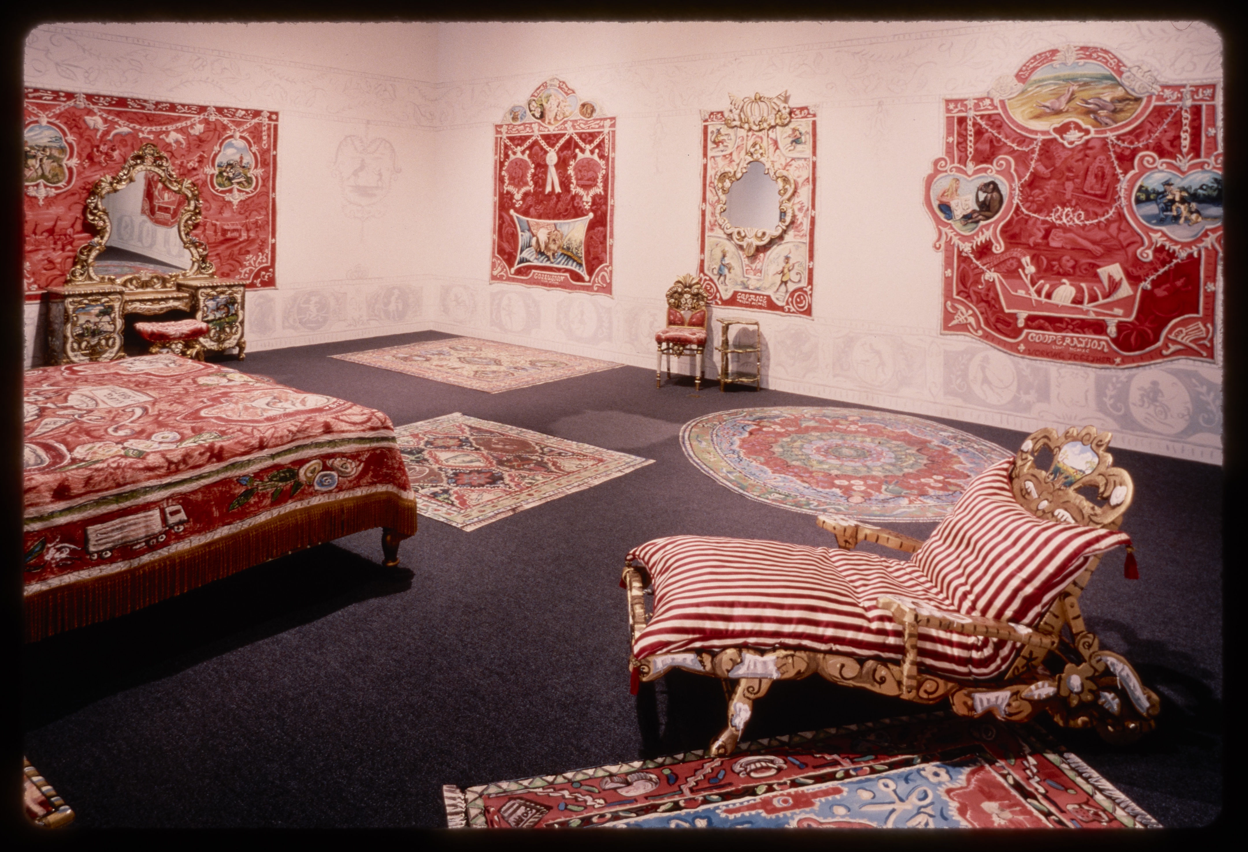 Red and white vintage carpets, furniture, chairs, and dressers fill a gallery room.