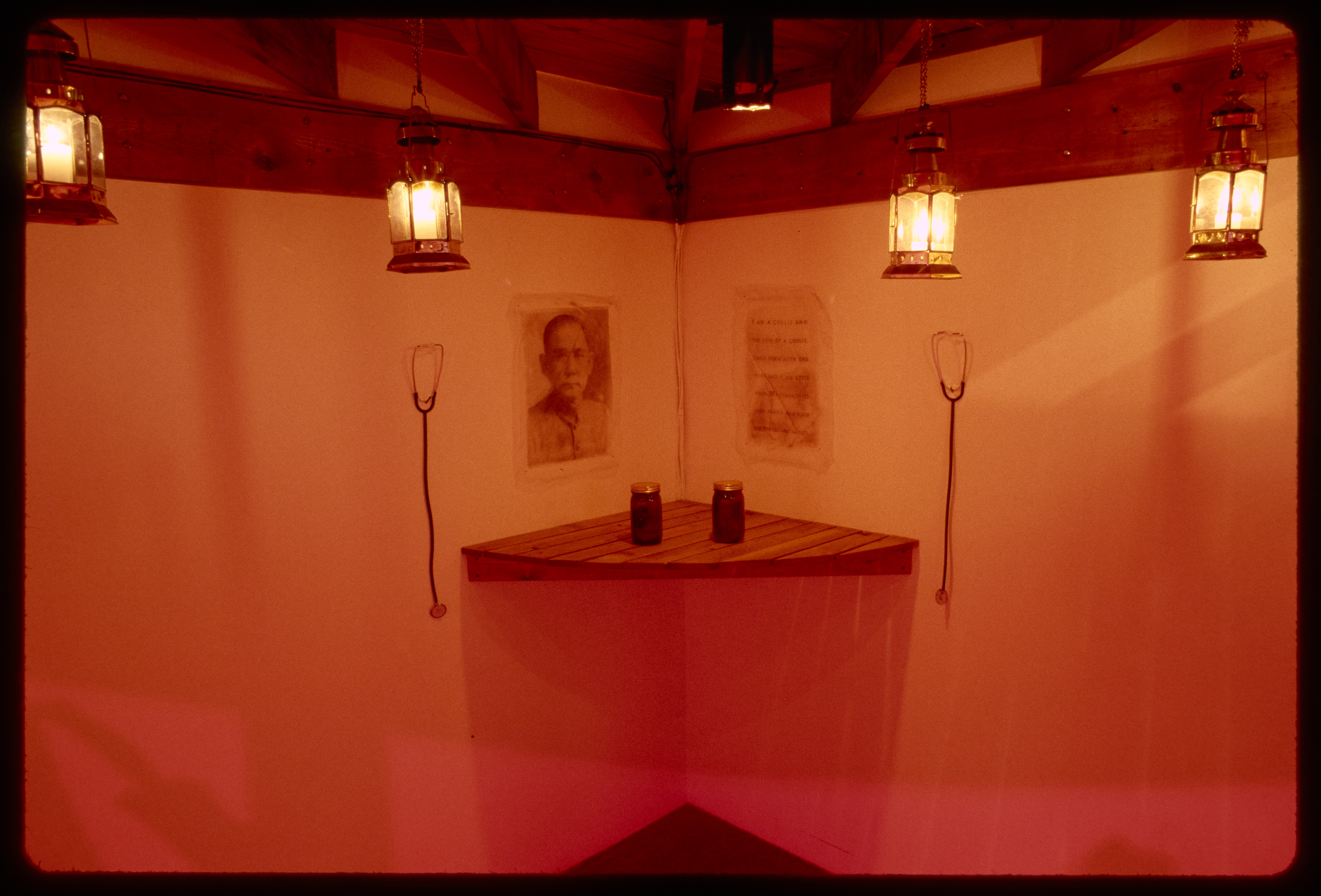 A surface juts from the corner holding two jars. On the wall are stethoscopes, an image of a Chinese man, and a letter.