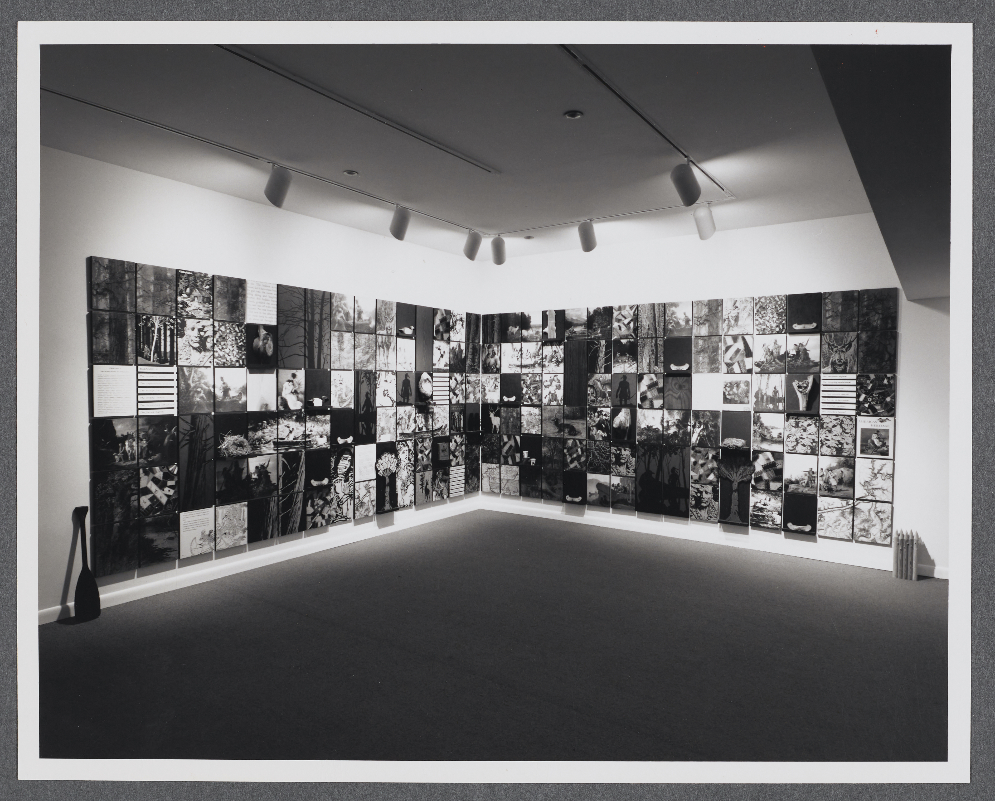 A grid of photographs of historical portraits, documents, and nature images extend across all of the gallery walls.