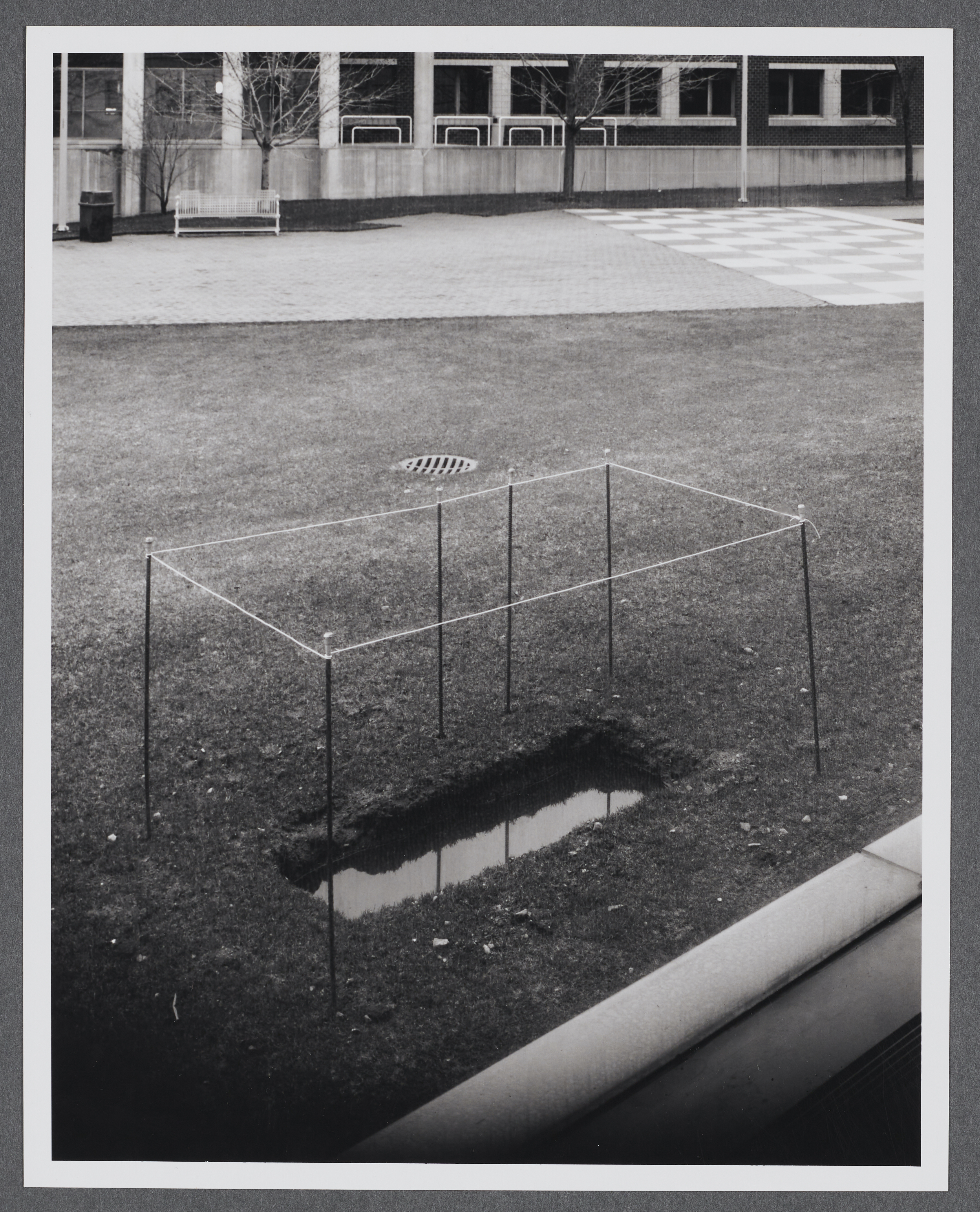 A rectangle has been dug into the ground and filled with water outside of the gallery.