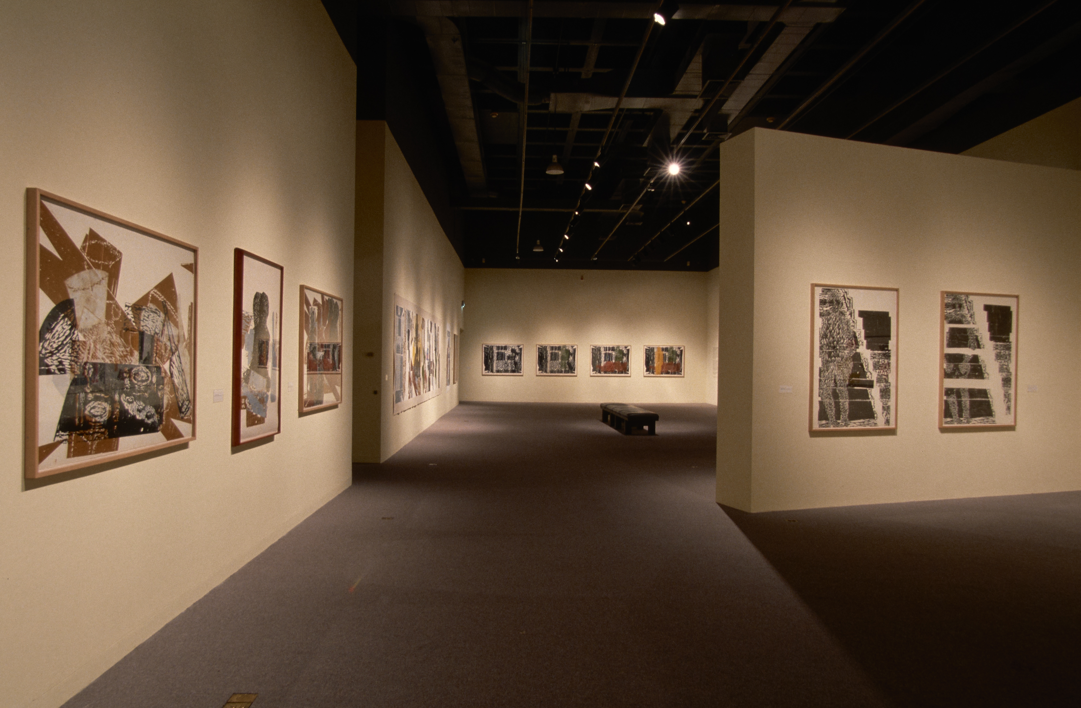 3 brown, black and white framed prints on a left foreground wall, 2 black and white woodblock prints on a center facing wall