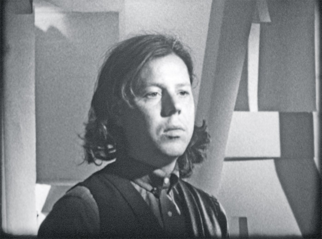 A black and white still of a woman looking off screen.