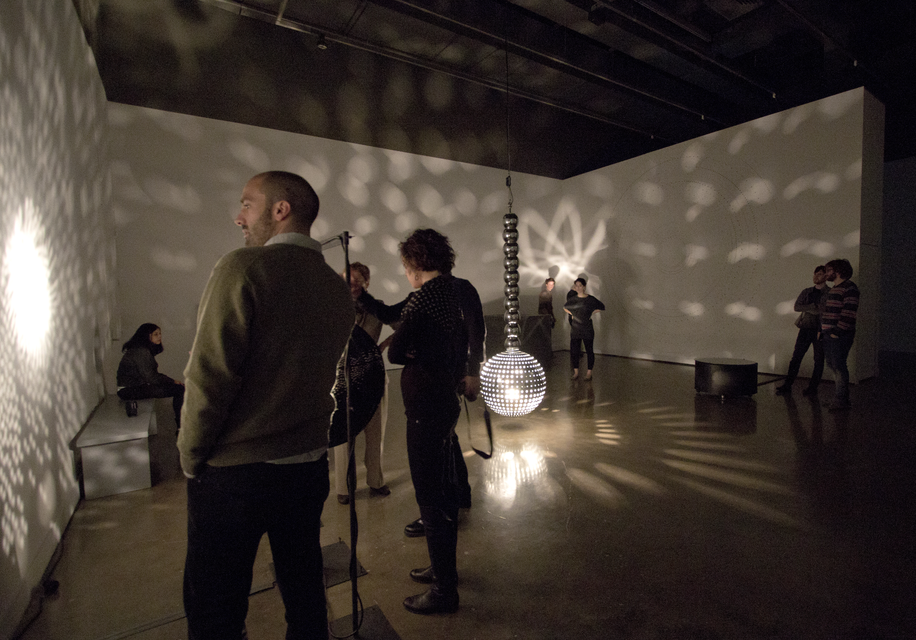Viewers looking at the works in a gallery.