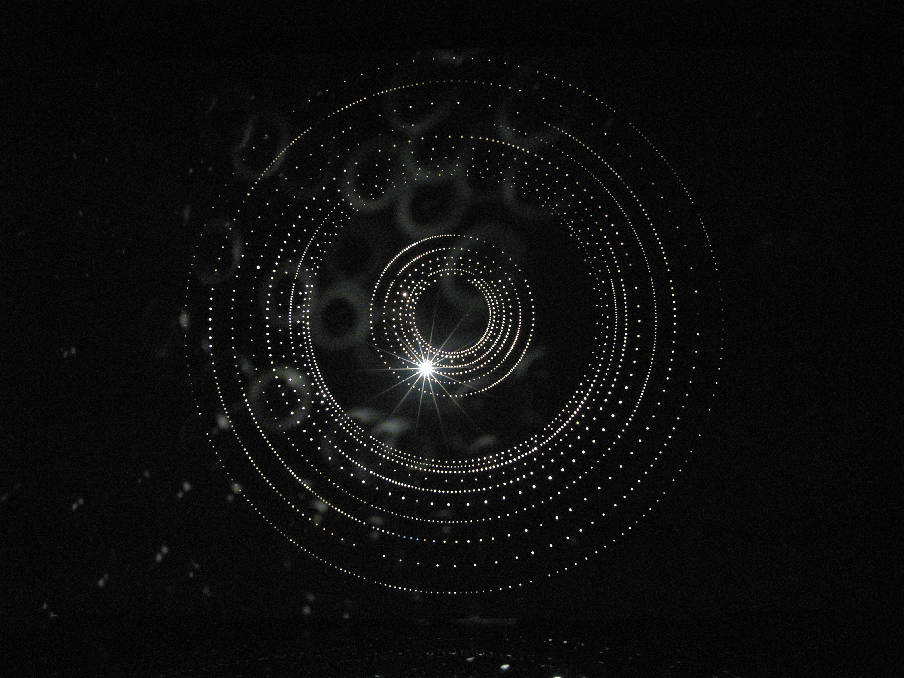 Small Lights installed in a circular motion on a black wall.