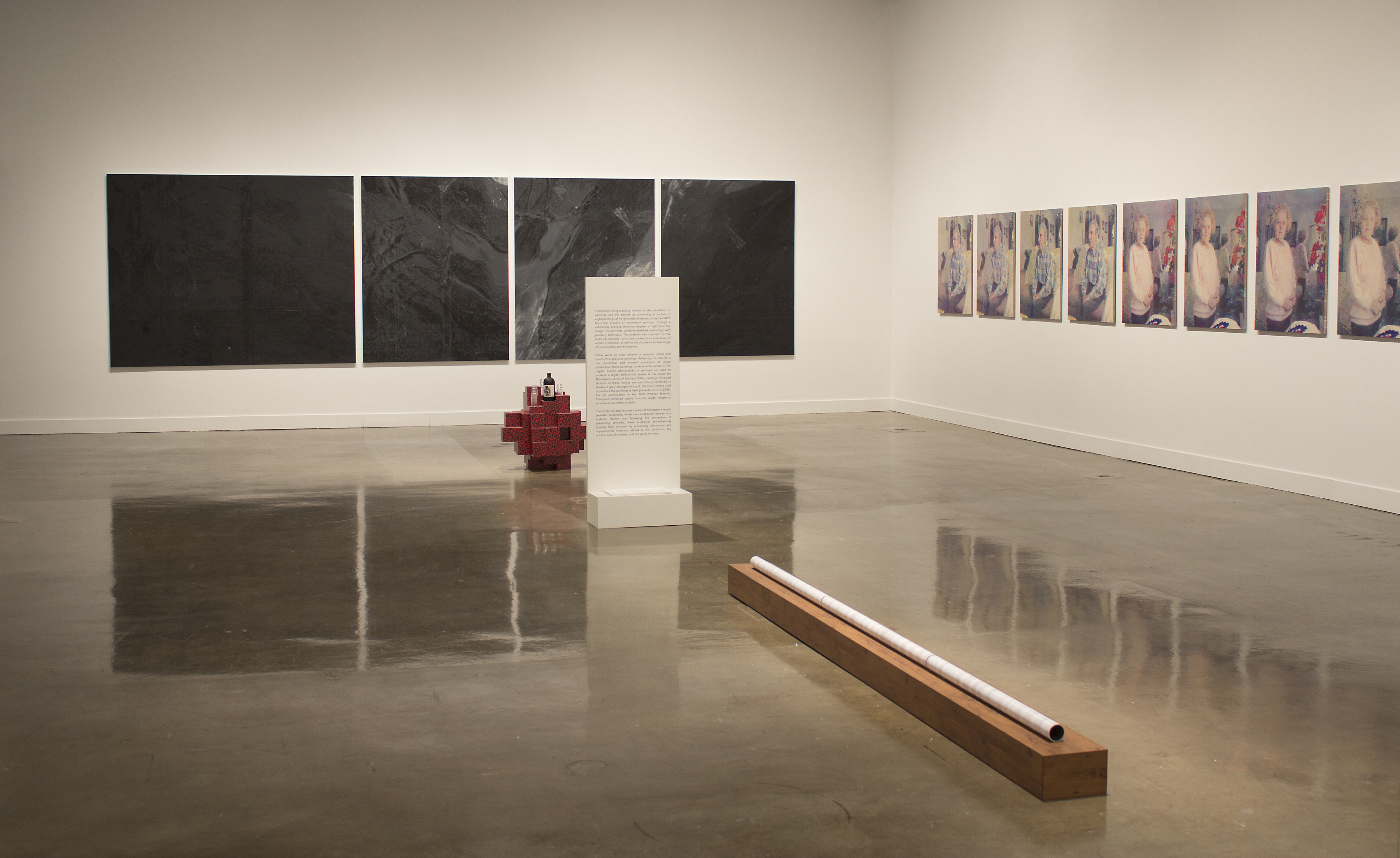 Corner shot of gallery with 2 mulit paneled paintings flanking each wall.