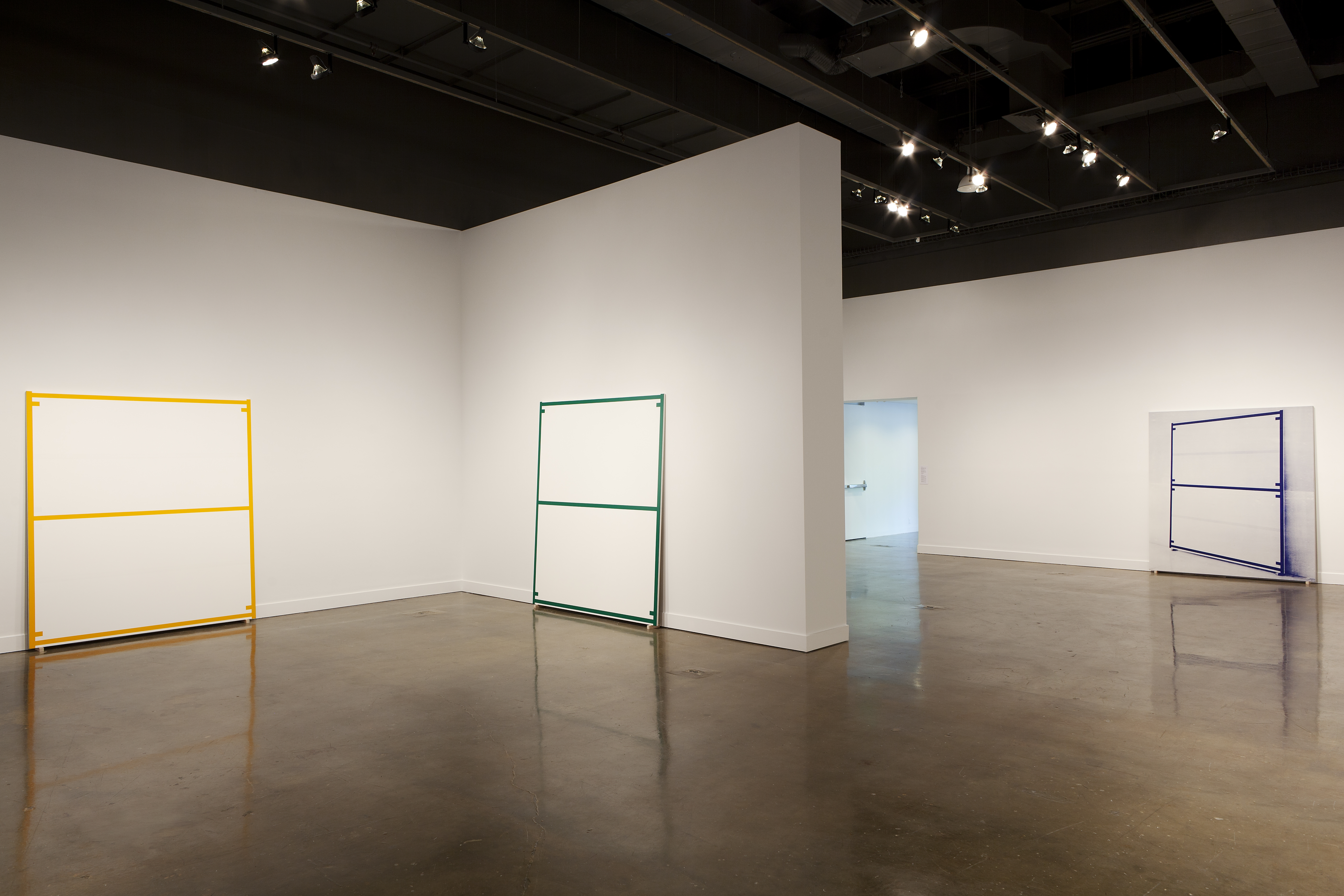 Three large canvases: two are edged and bisected with a colored line; the third has an image edged and bisected with a colored line.