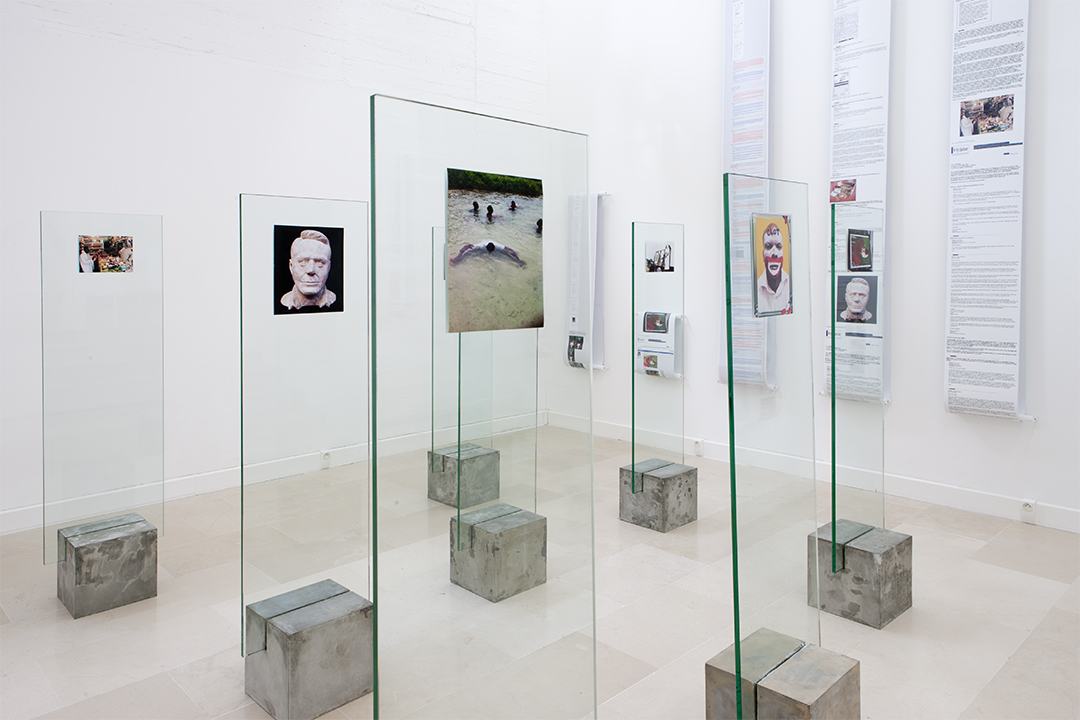 Installation of multiple glass panels and photographs are placed into concrete blocks.