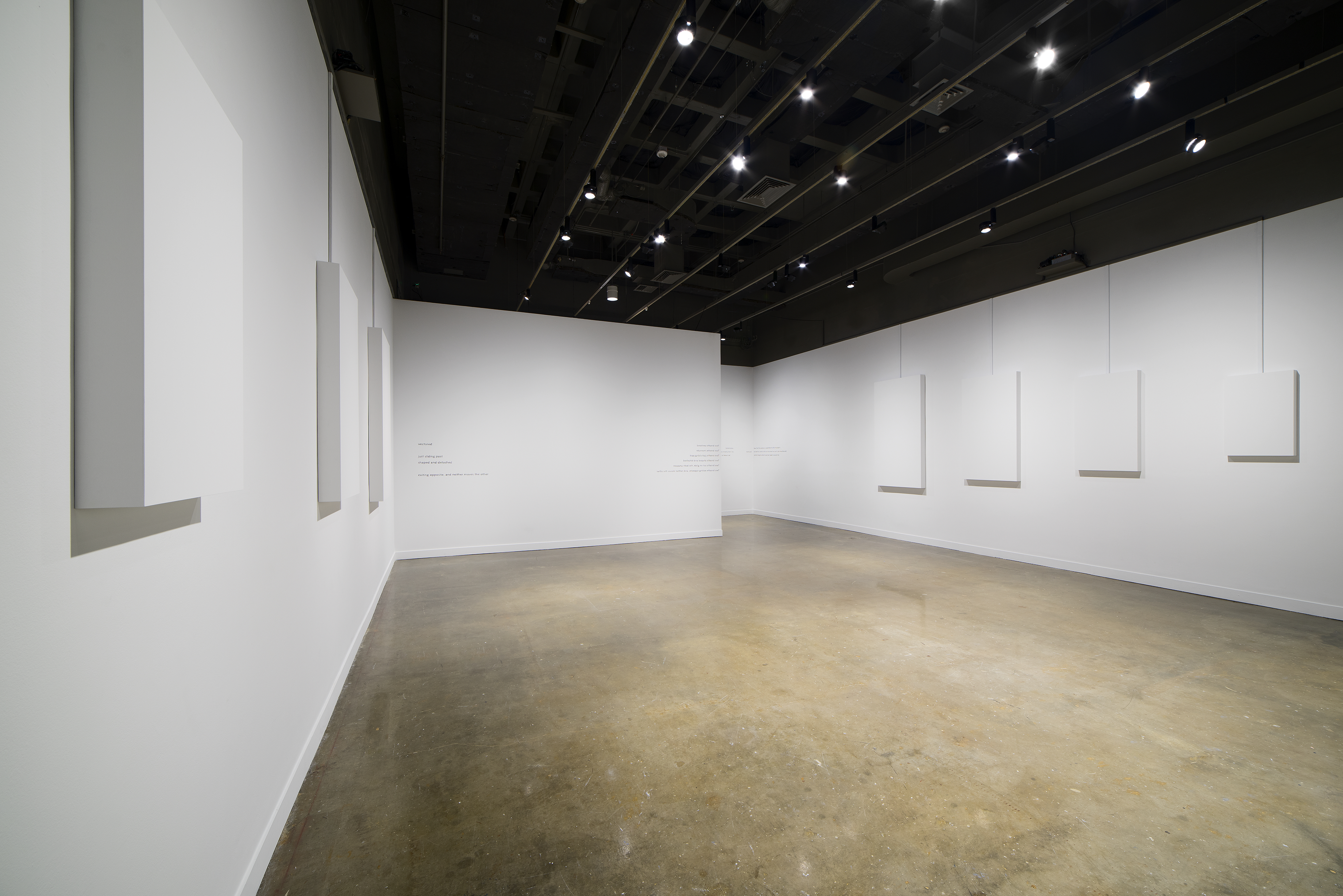 White rectangles of descending size line the left and right white walls, while the center wall has text written in pencil.