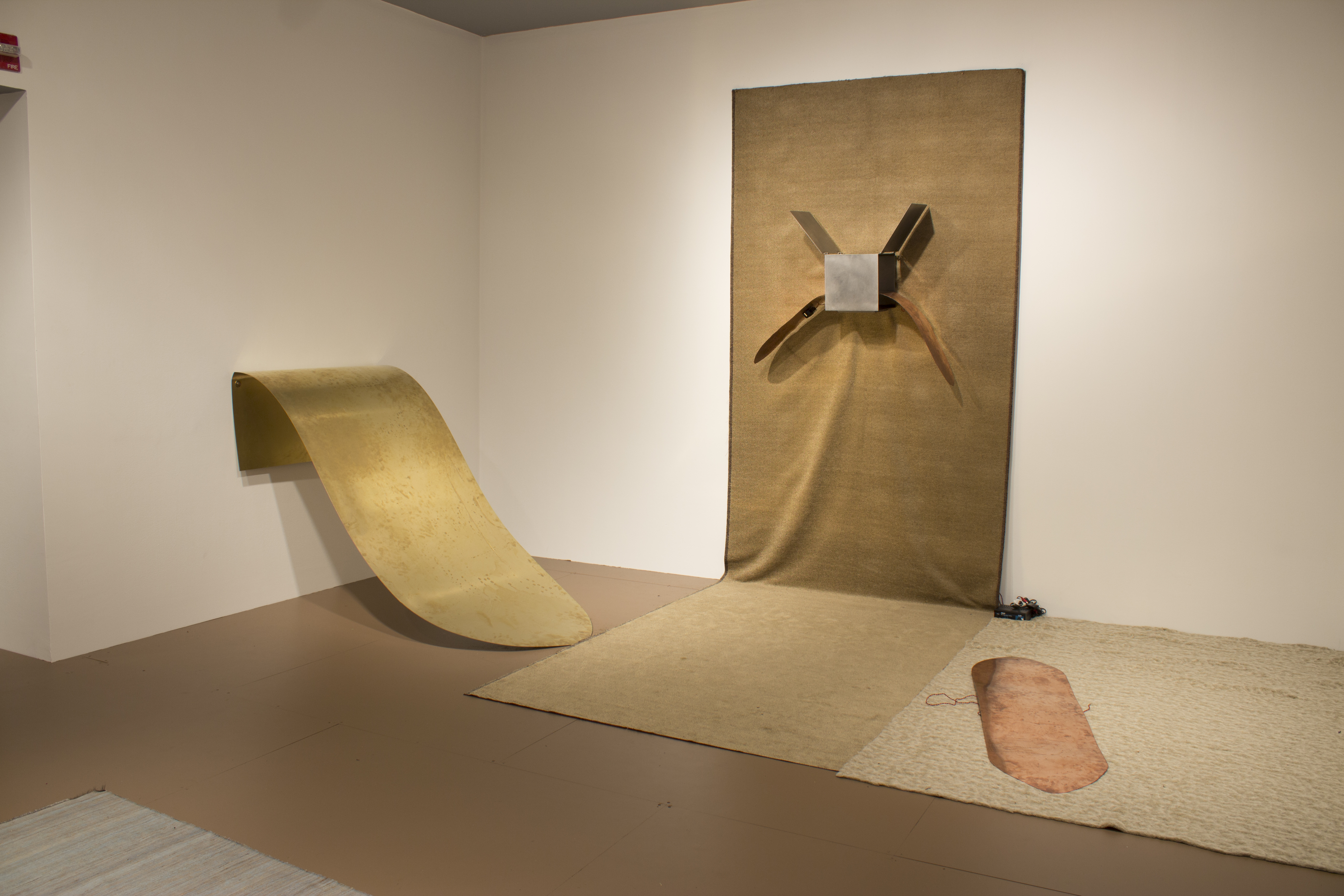 A wide piece of metal sloping down from the wall. A smaller piece of metal on the floor. A metal object in the shape of an X.