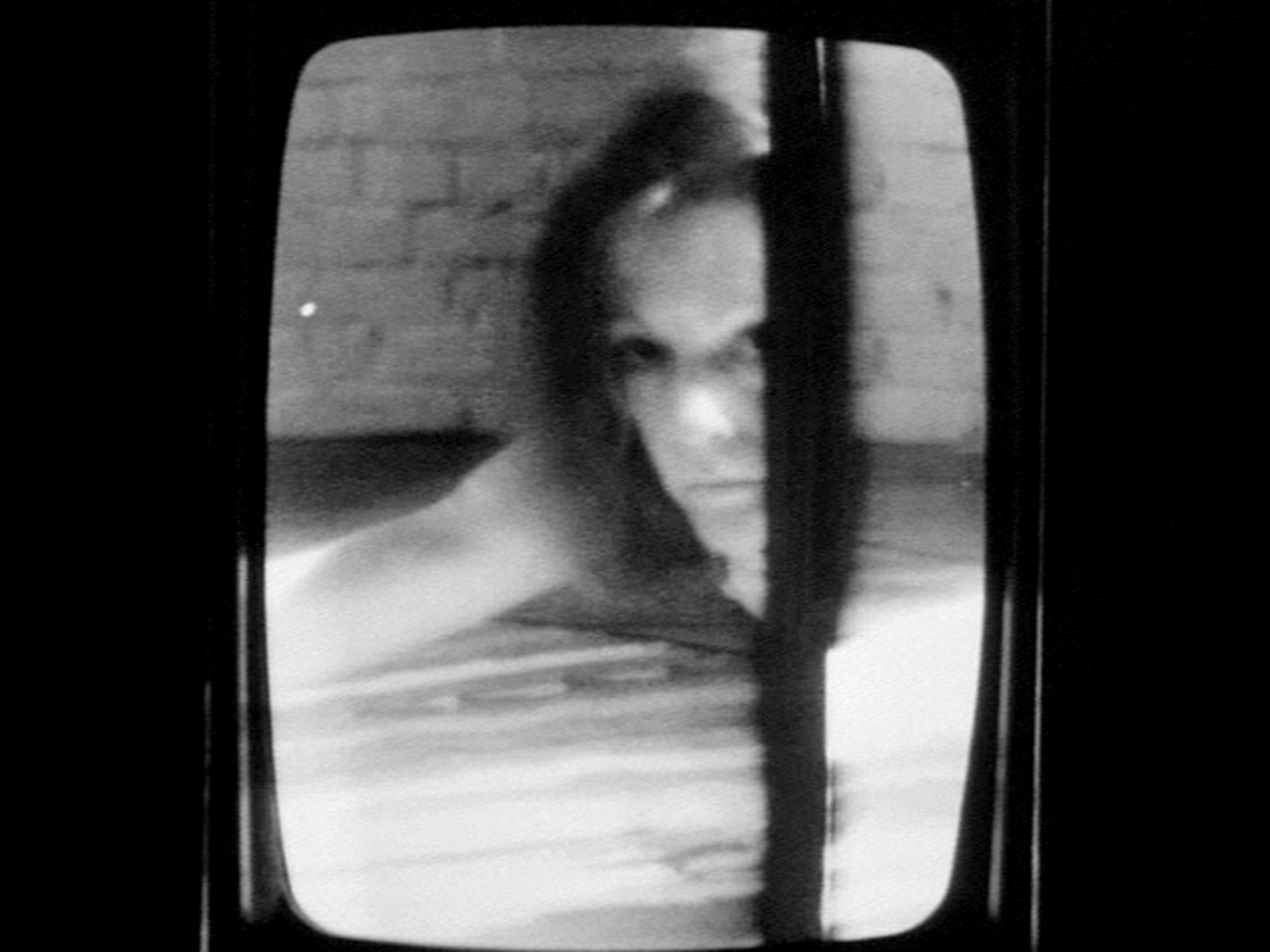 Black and White Close up of a woman as seen through a window.