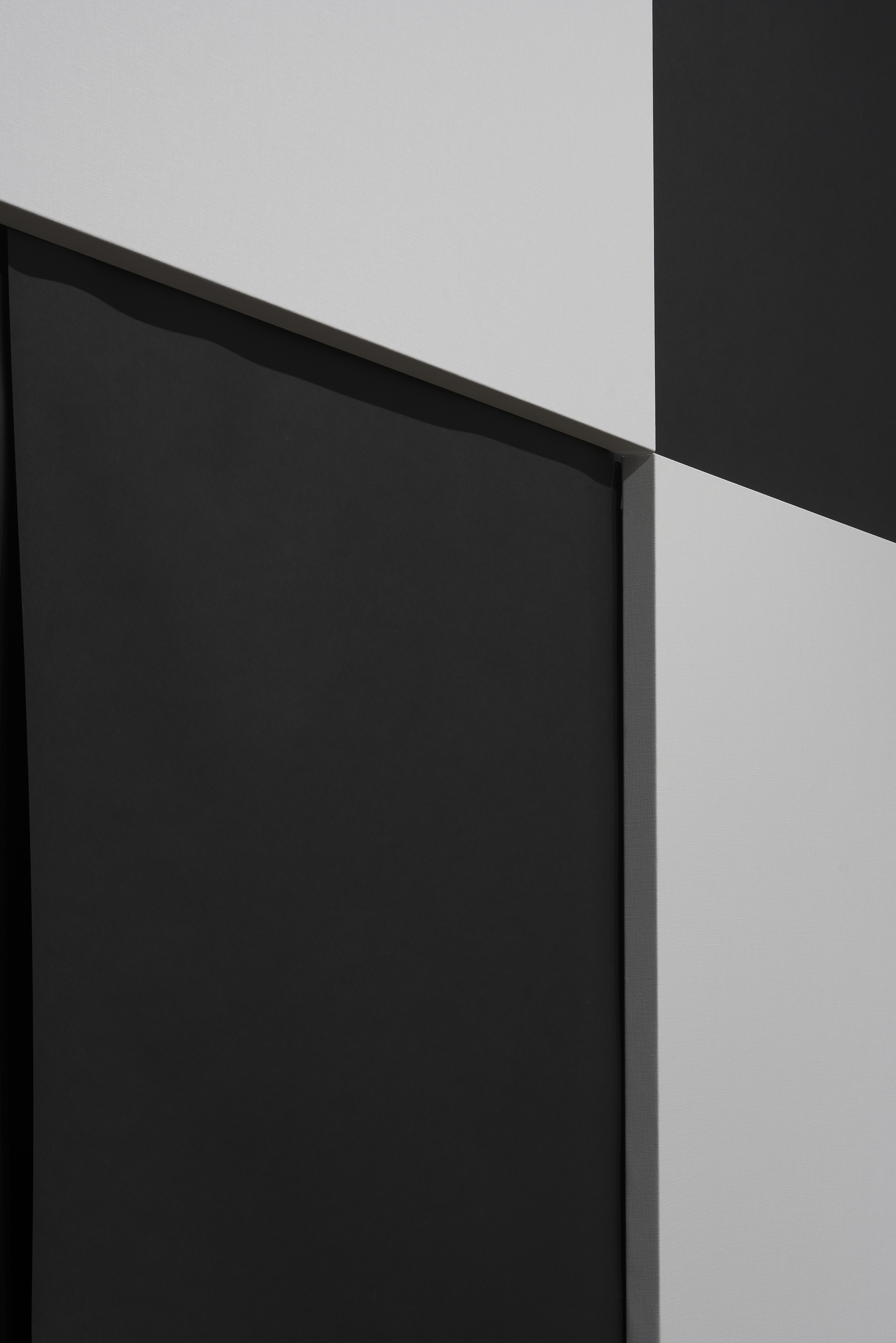 The intersection of 4 squares in a black and white checkerboard pattern. The white squares are raised panels.