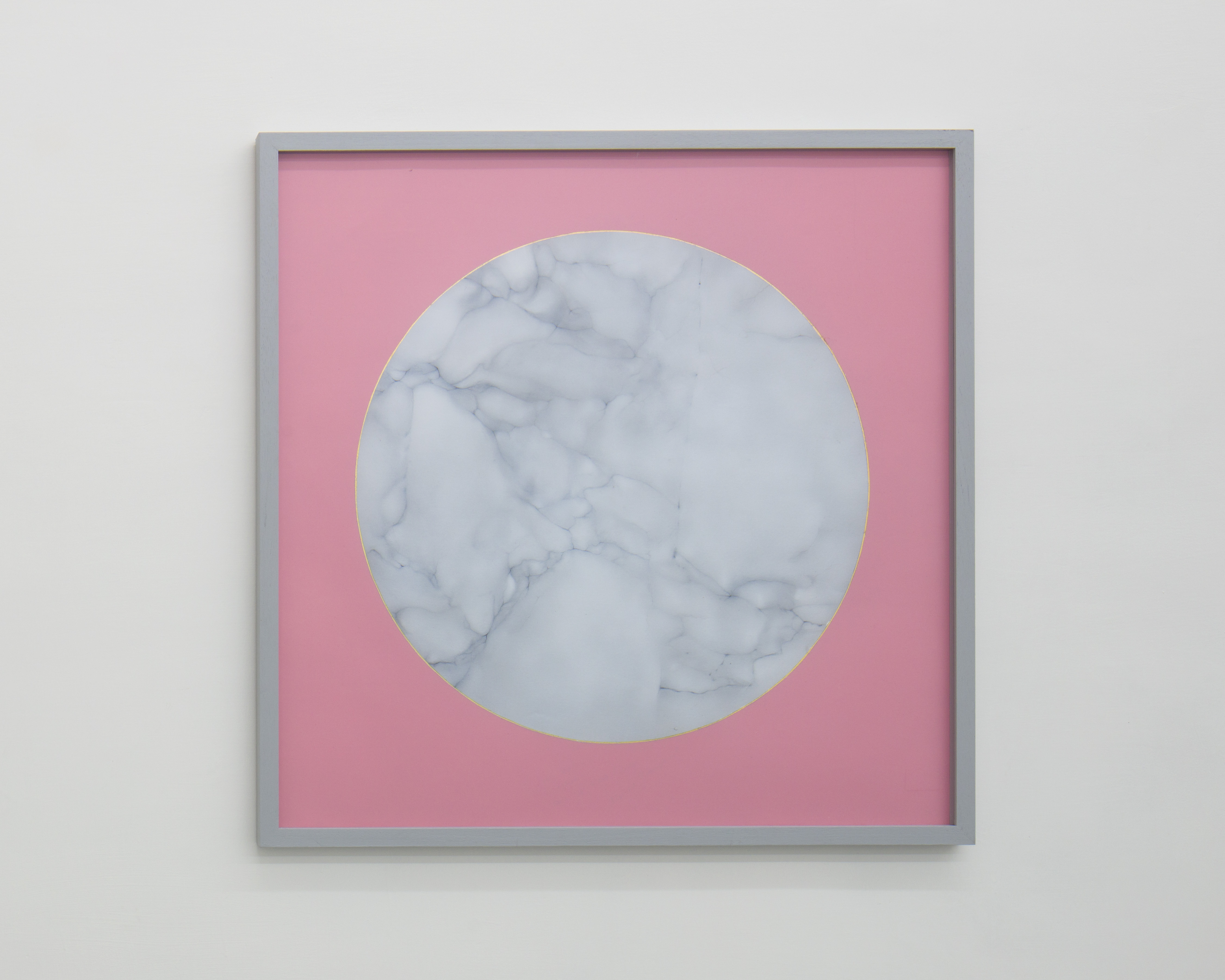 Gray square frame surrounds a painting of a circle of white veined marble, outlined with gold leaf on pink paper.
