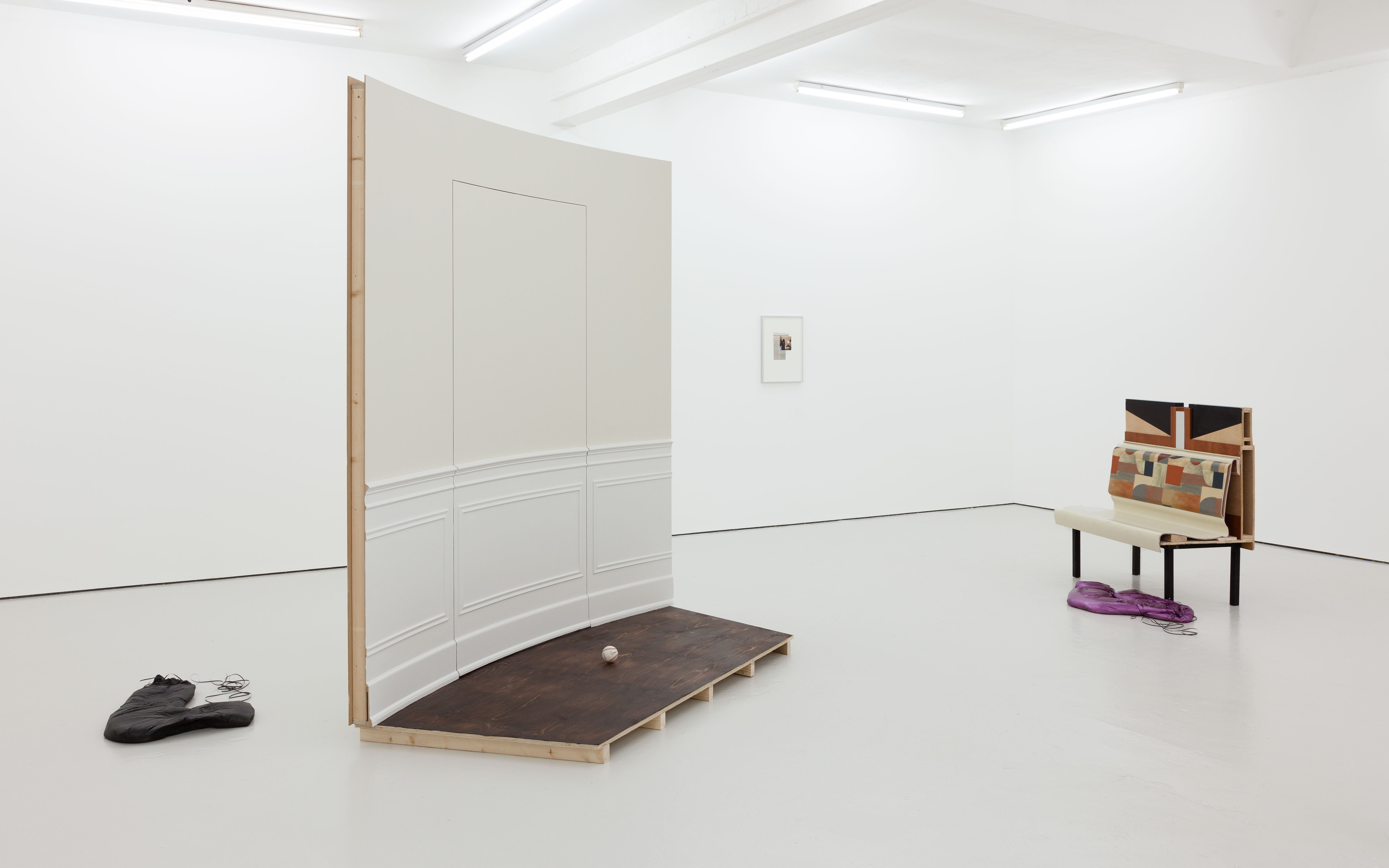There are two sculptures consisting of wall molding and wood in a gallery space.
