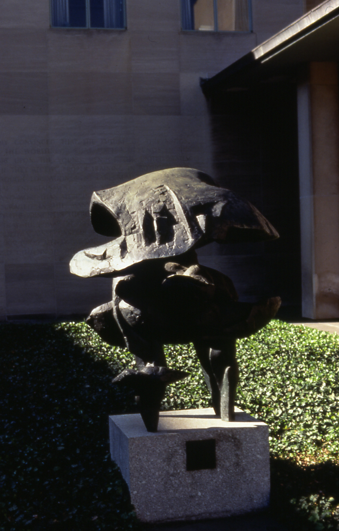 Abstract bronze sculpture in a courtyard.