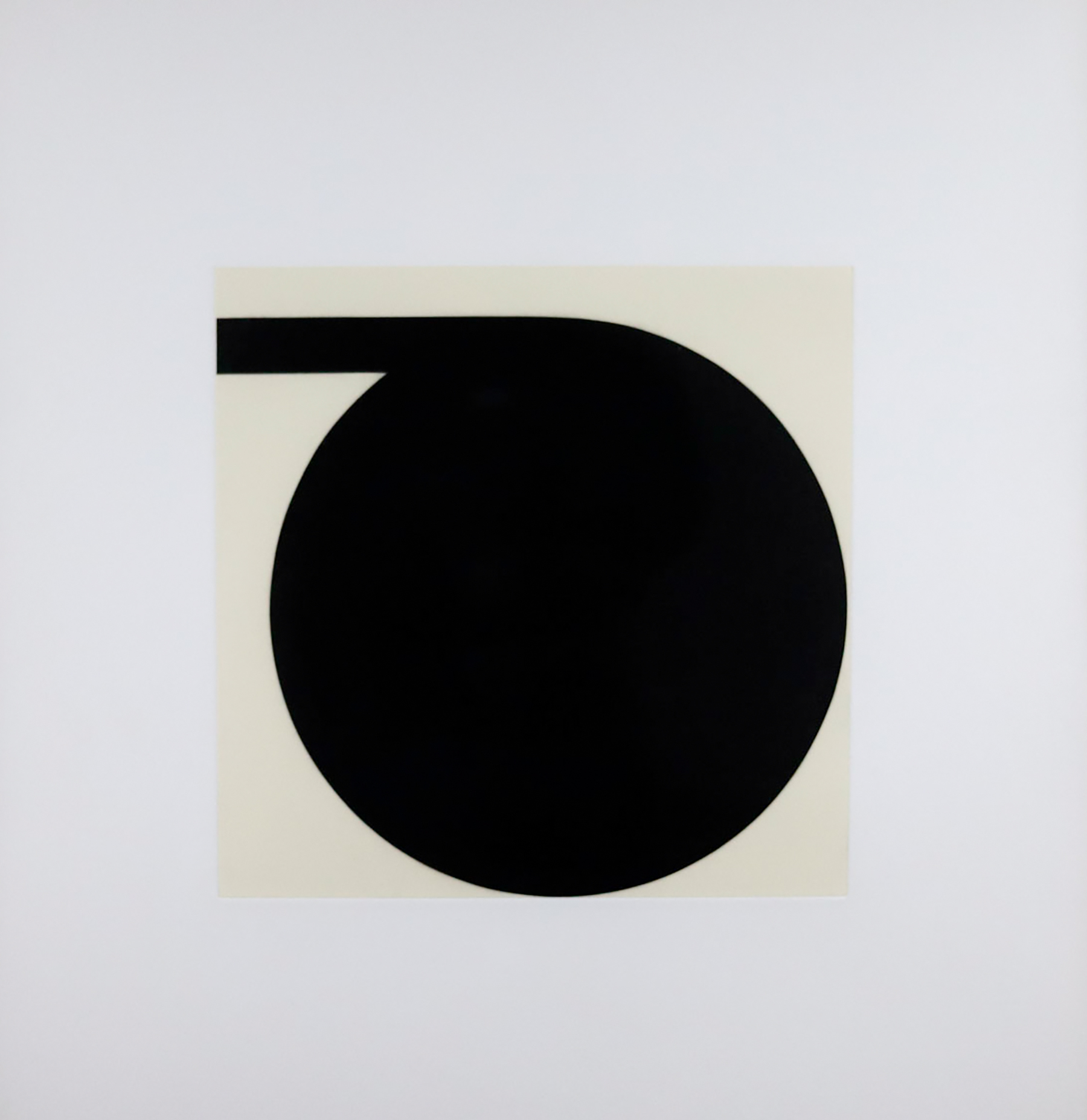 Cream colors square with a black circle touching the right and bottom edge and a thick black line coming out of the circle going to the left edge.