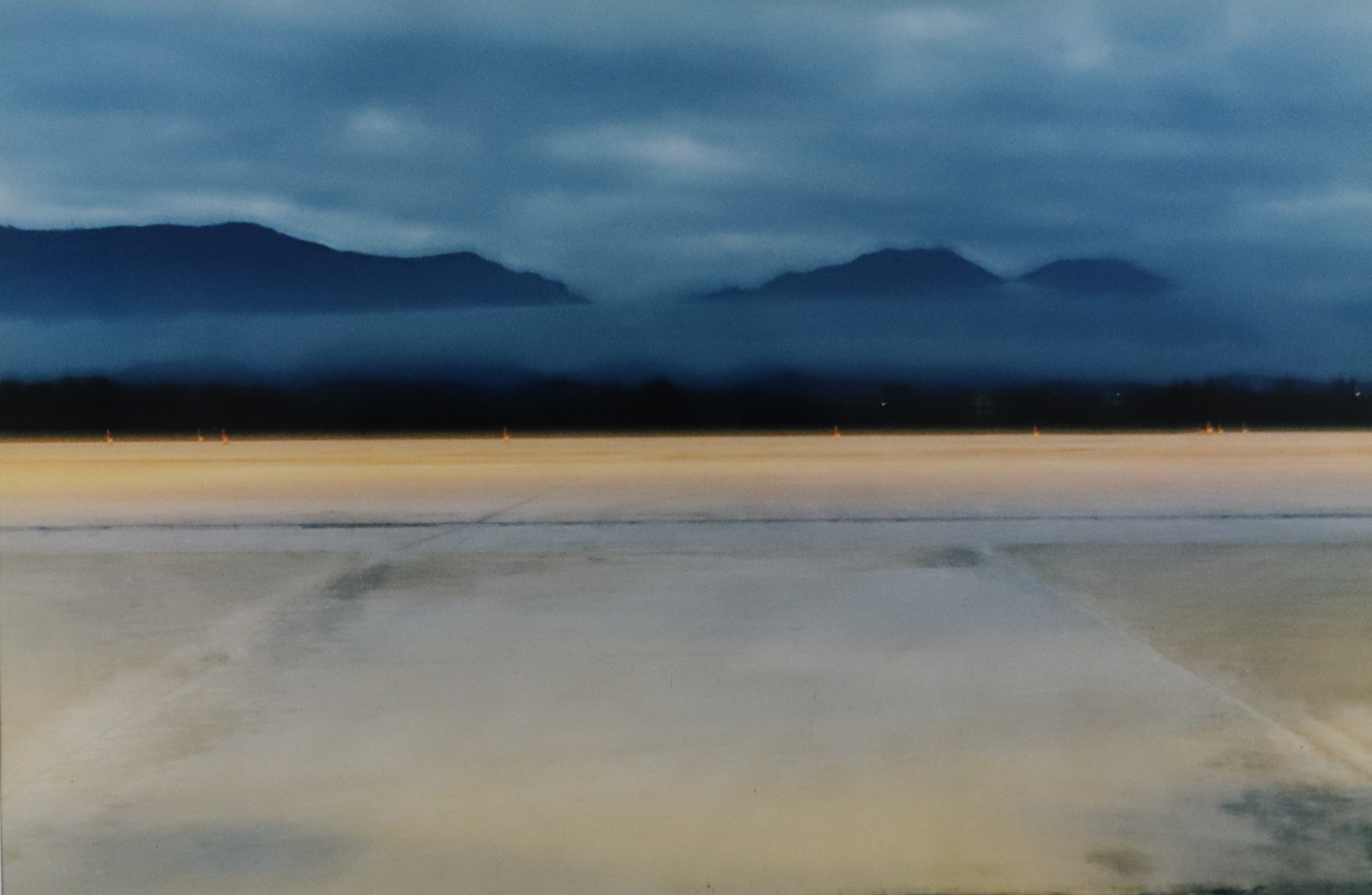Photograph with lots of fog, clouds and a mountain range in the background.
