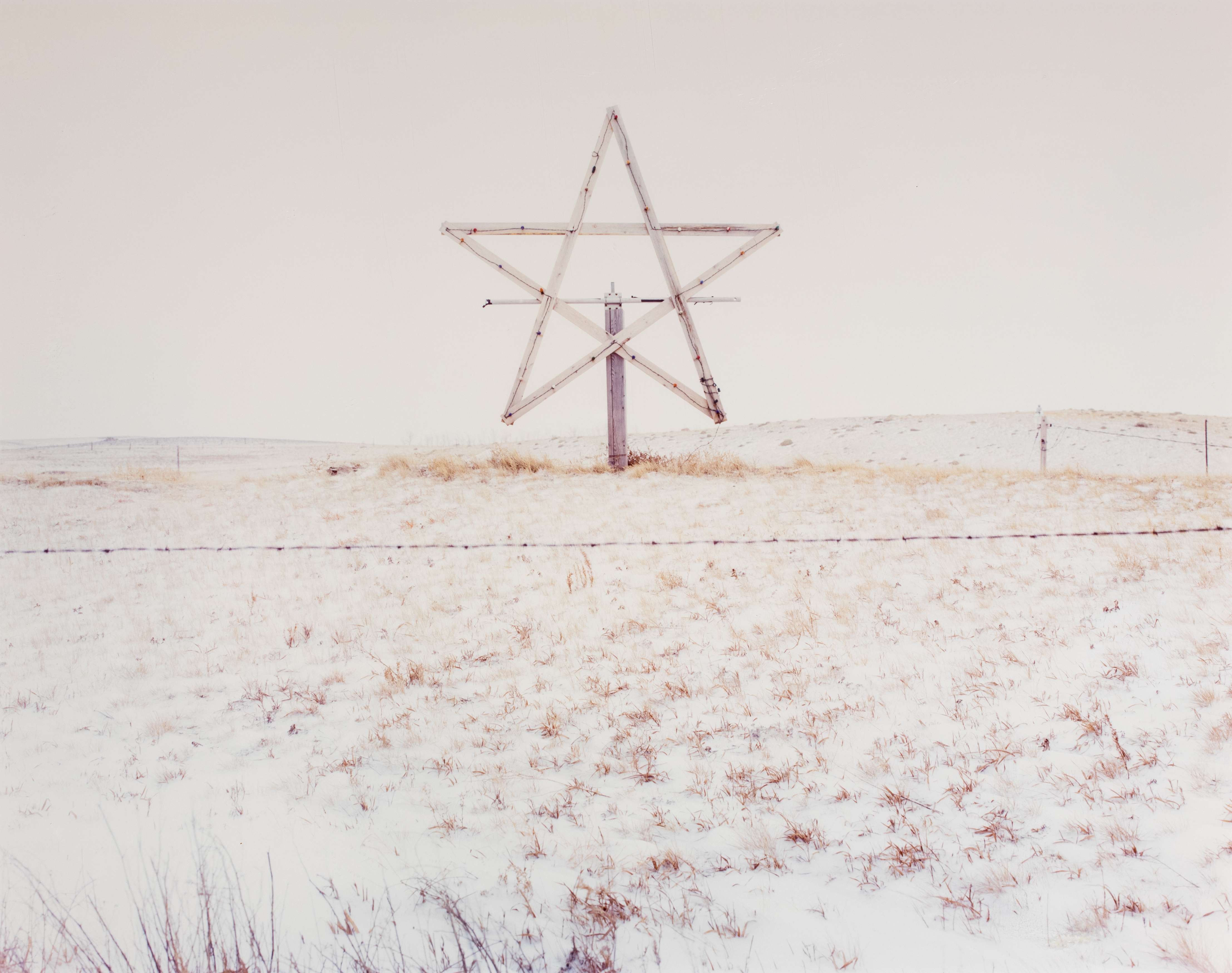 Wooden sculpture of the Star of David photographed on a sand dune.