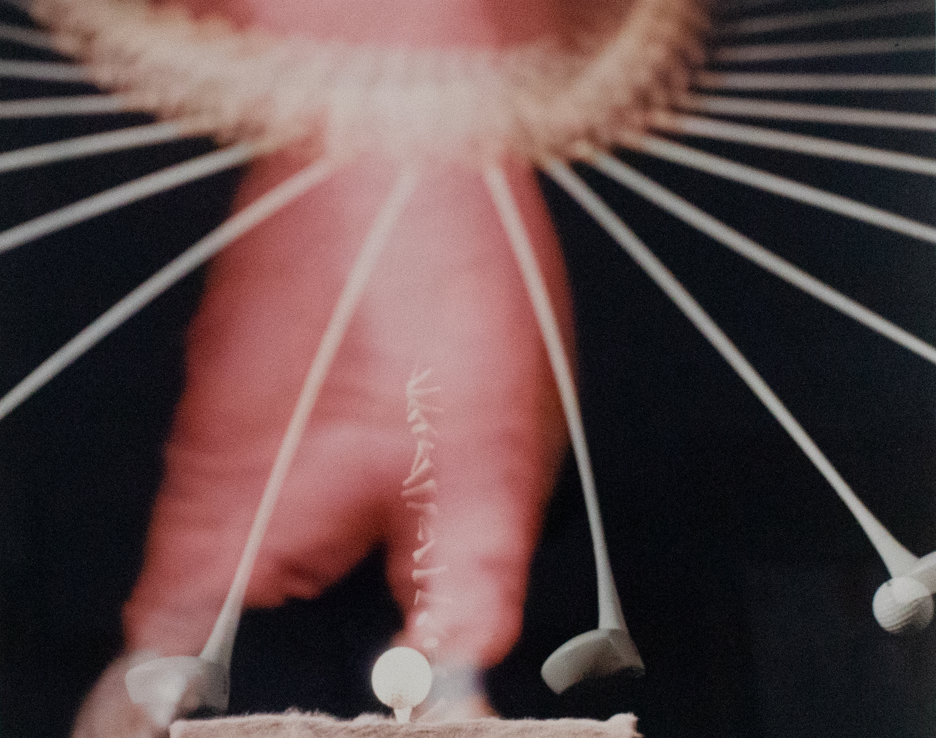 Long exposure of a golf ball on a tee being hit by a player wearing red.