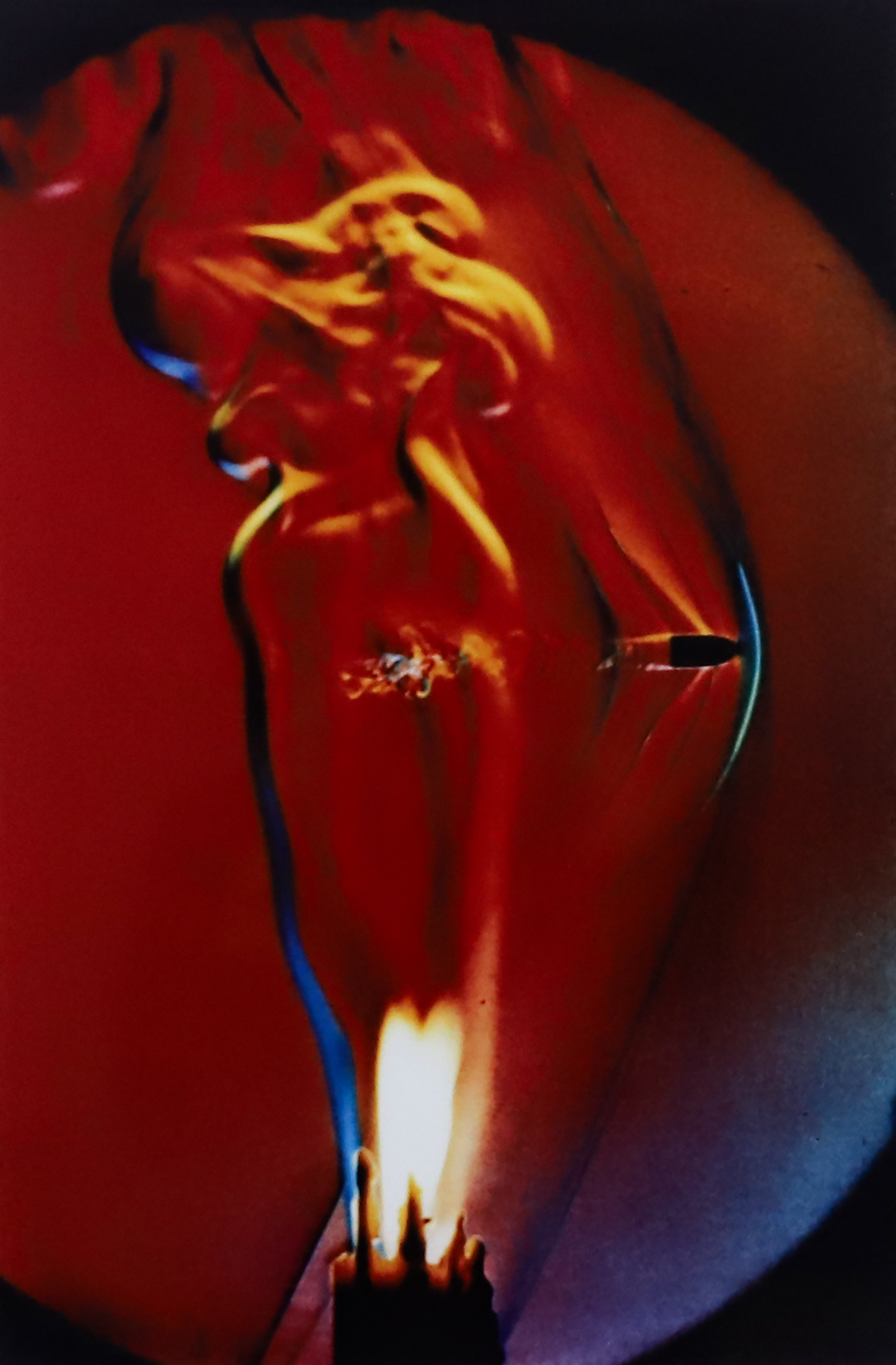 Close up of a bullet shooting through a flame.