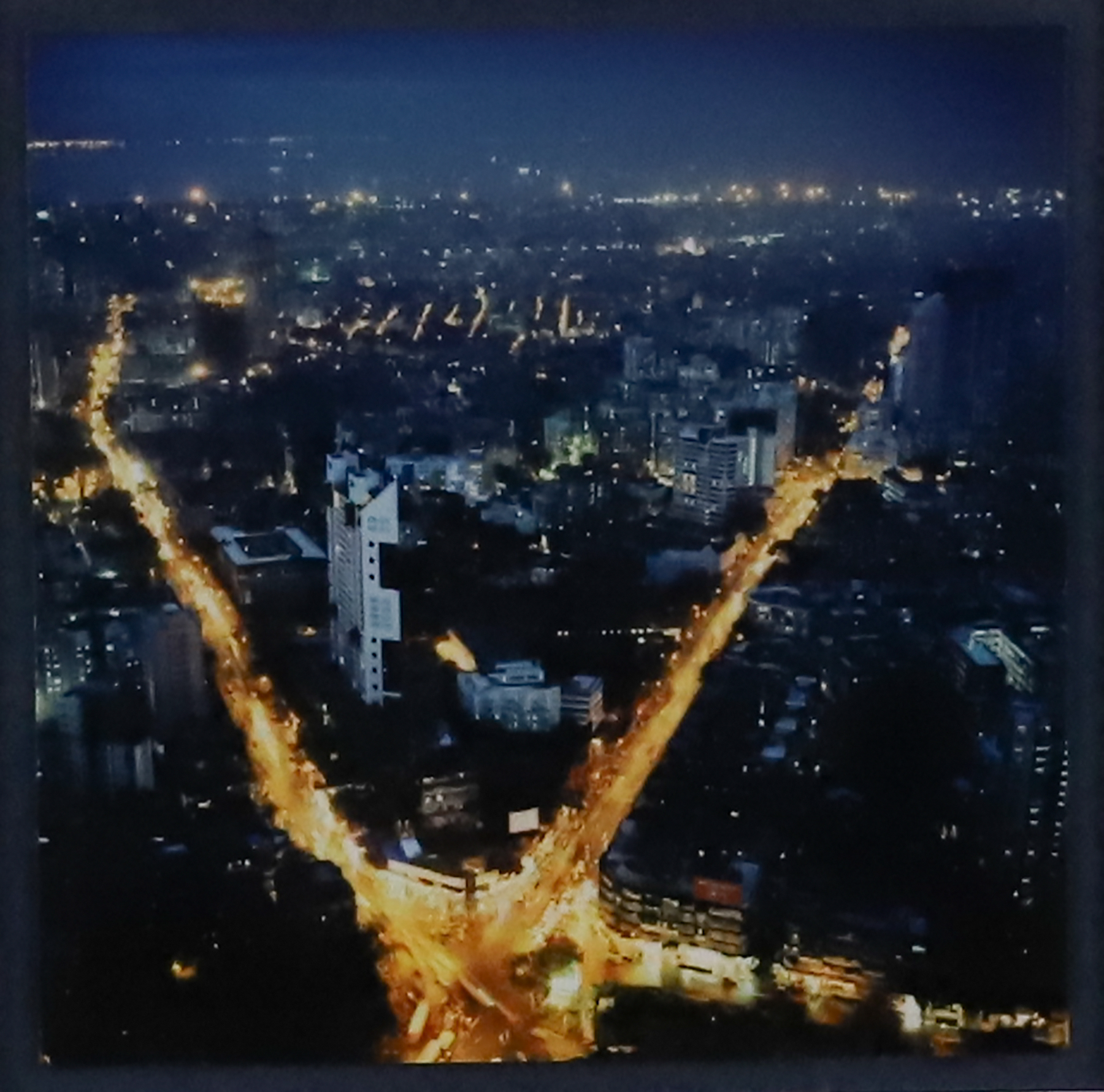 Long exposure of a city street with two main roads lit by car and street lights.