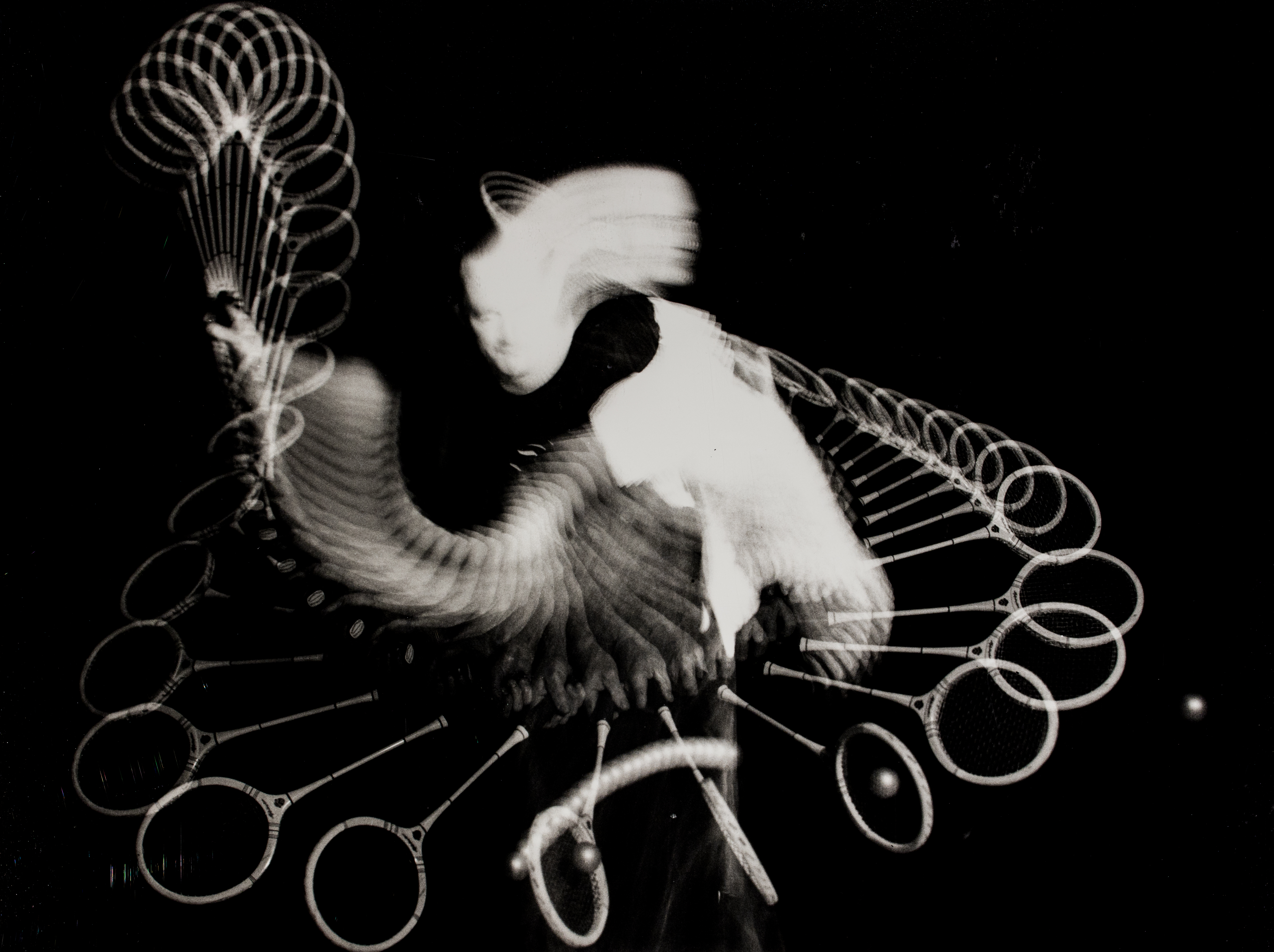 Long exposure image of a person swinging a squash racket.