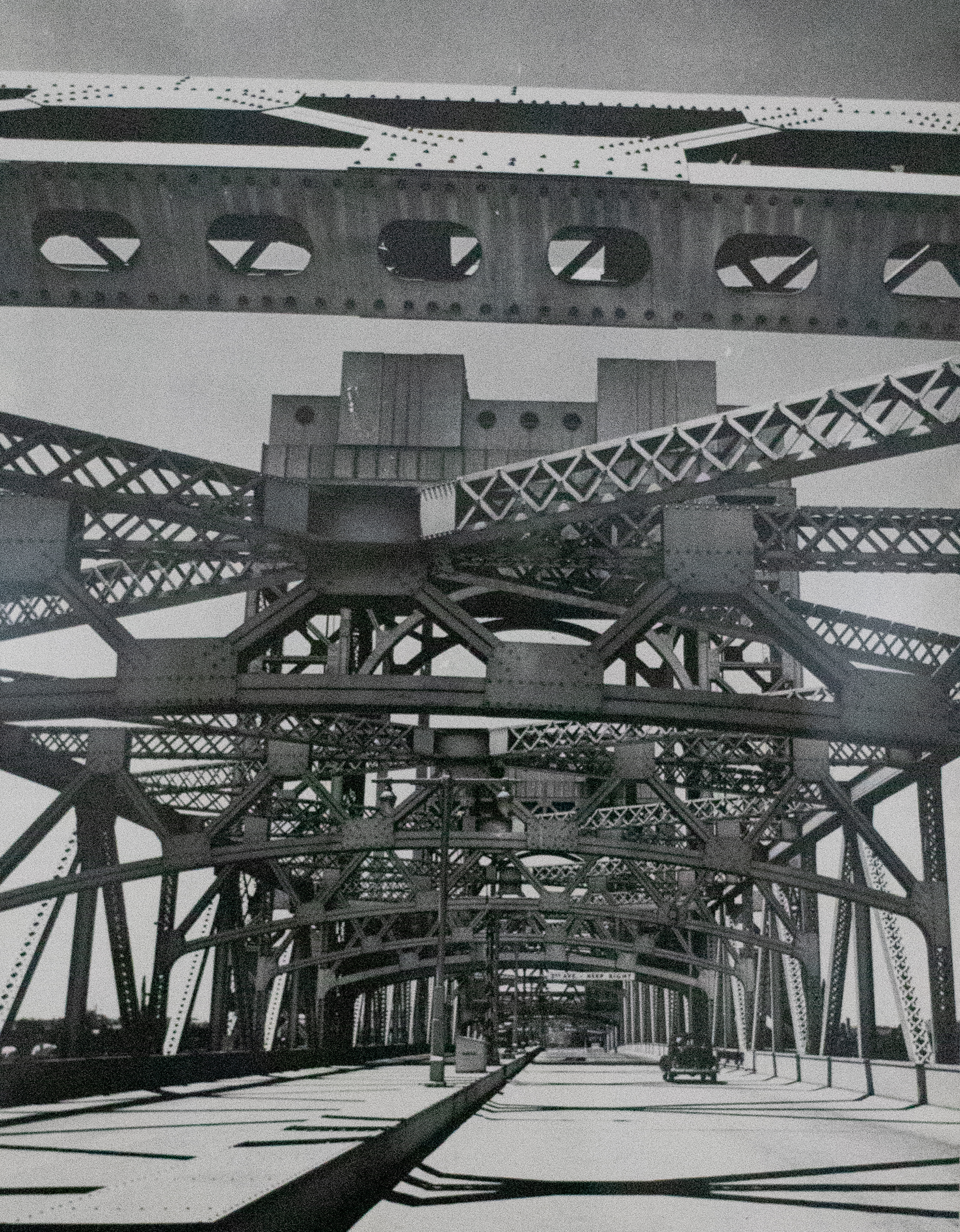 Black and white photograph of a steel bridge from underneath.