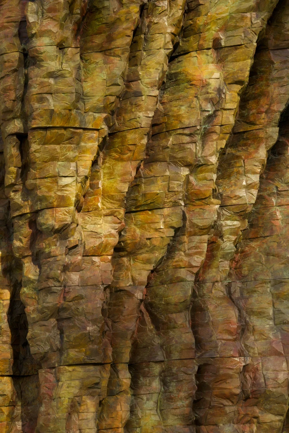 Close up of a bronze sculpture with texture that resembles tree bark.