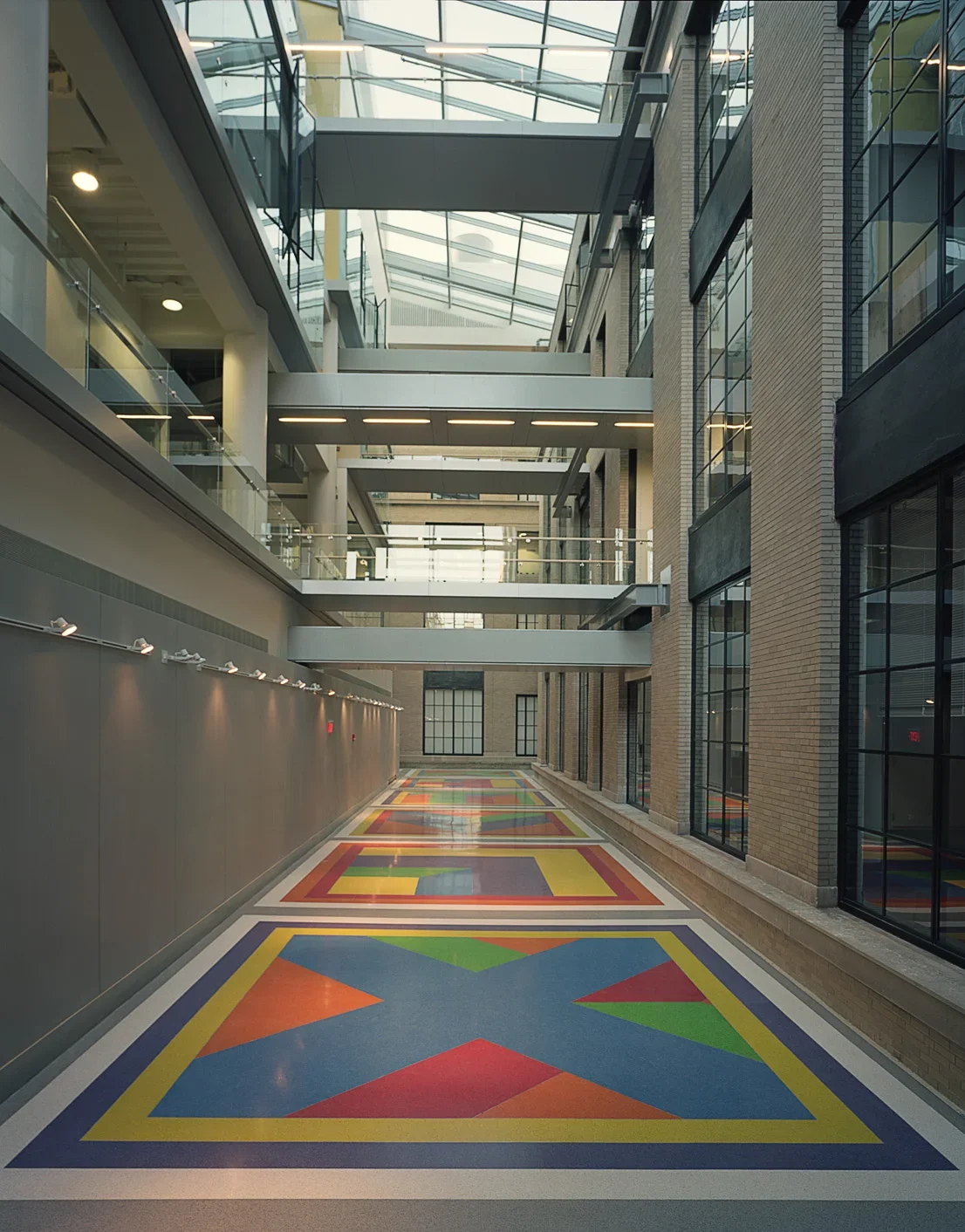 Sol Lewitt's colorful Terrazzo floor including red, green, orange, purple, and yellow tiles inside a building with high ceilings.