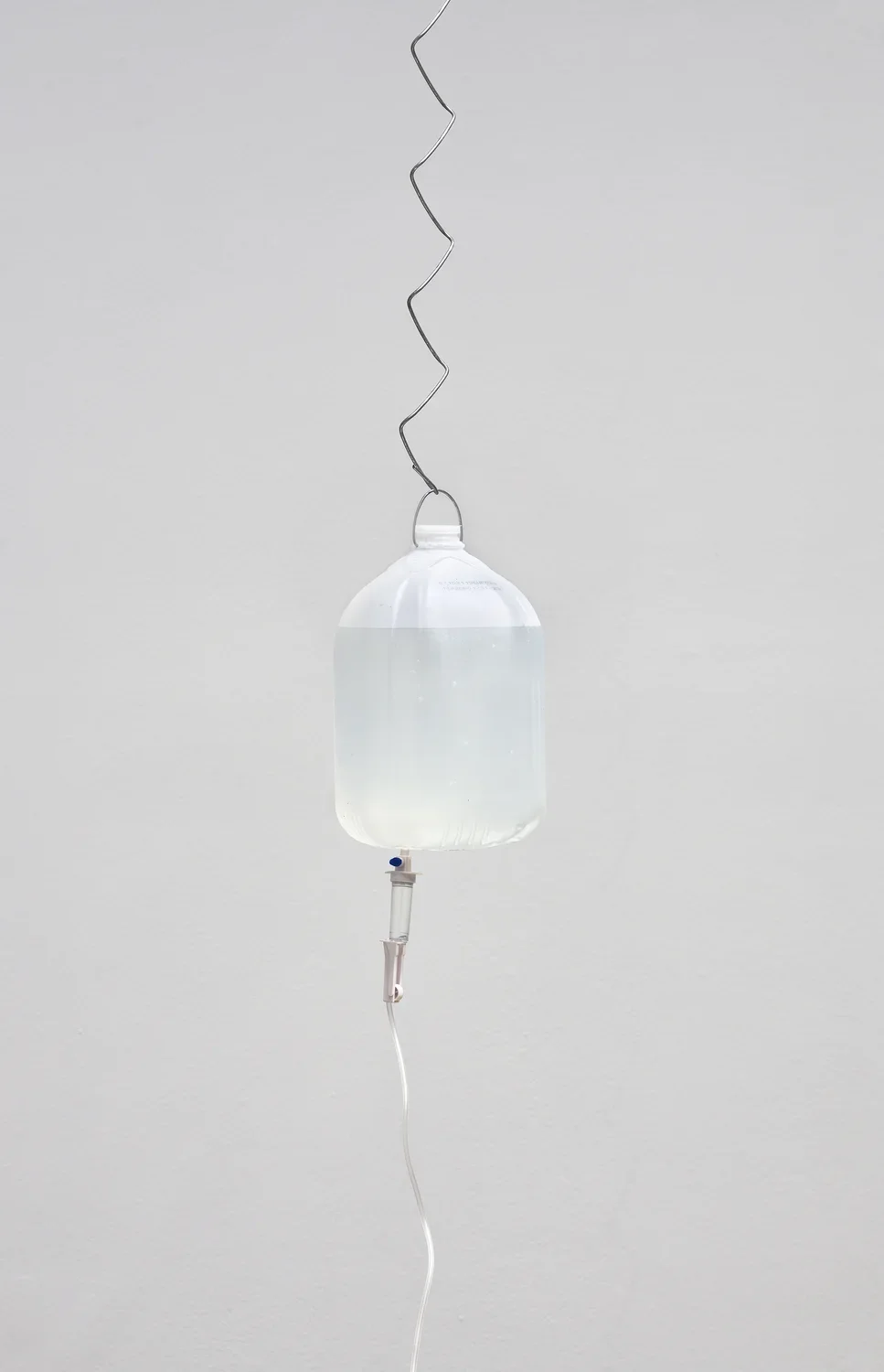 Chain link wire attached to a water bottle suspended in the air.