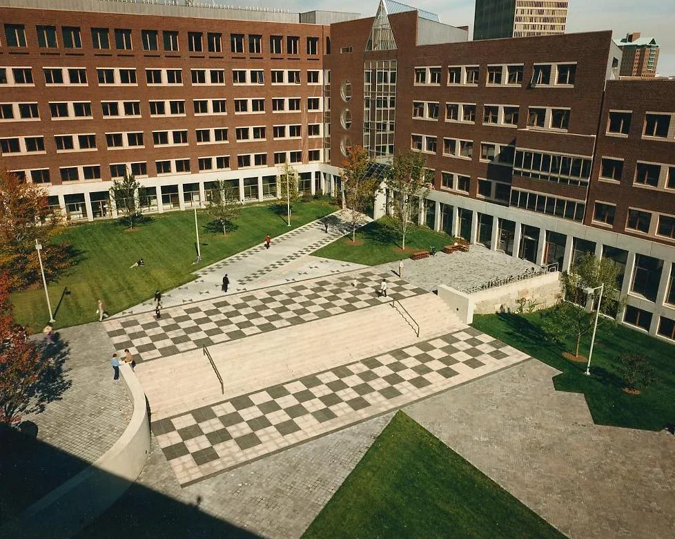 Courtyard with greenspace and brick buildings in the backyard.