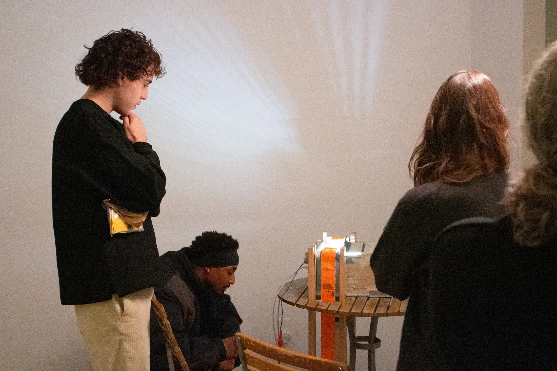 A group of students looking at the art piece titled Deltille-d Wall's Necessary Anachronism 2 by Sophie Friedman-Pappas